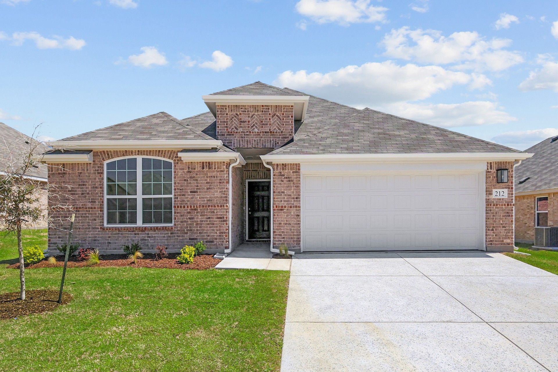 Modern Brick Home at Still Water Lake Estates with Arched Window and Garage:Elegant brick facade and arched windows blend timeless beauty and modern luxury at Still Water Lake Estates.