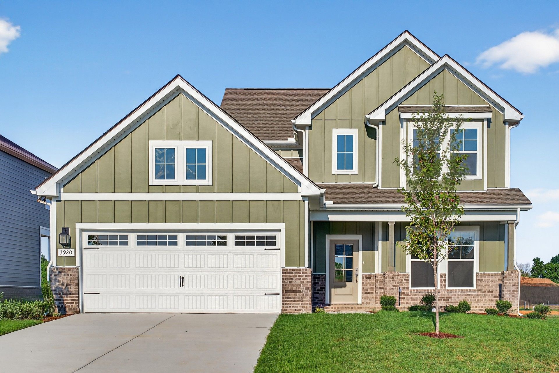 Two-Story Green House at McClure Farms:Exquisite McClure Farms residence featuring stylish green facade, classic brickwork, pristine garage.