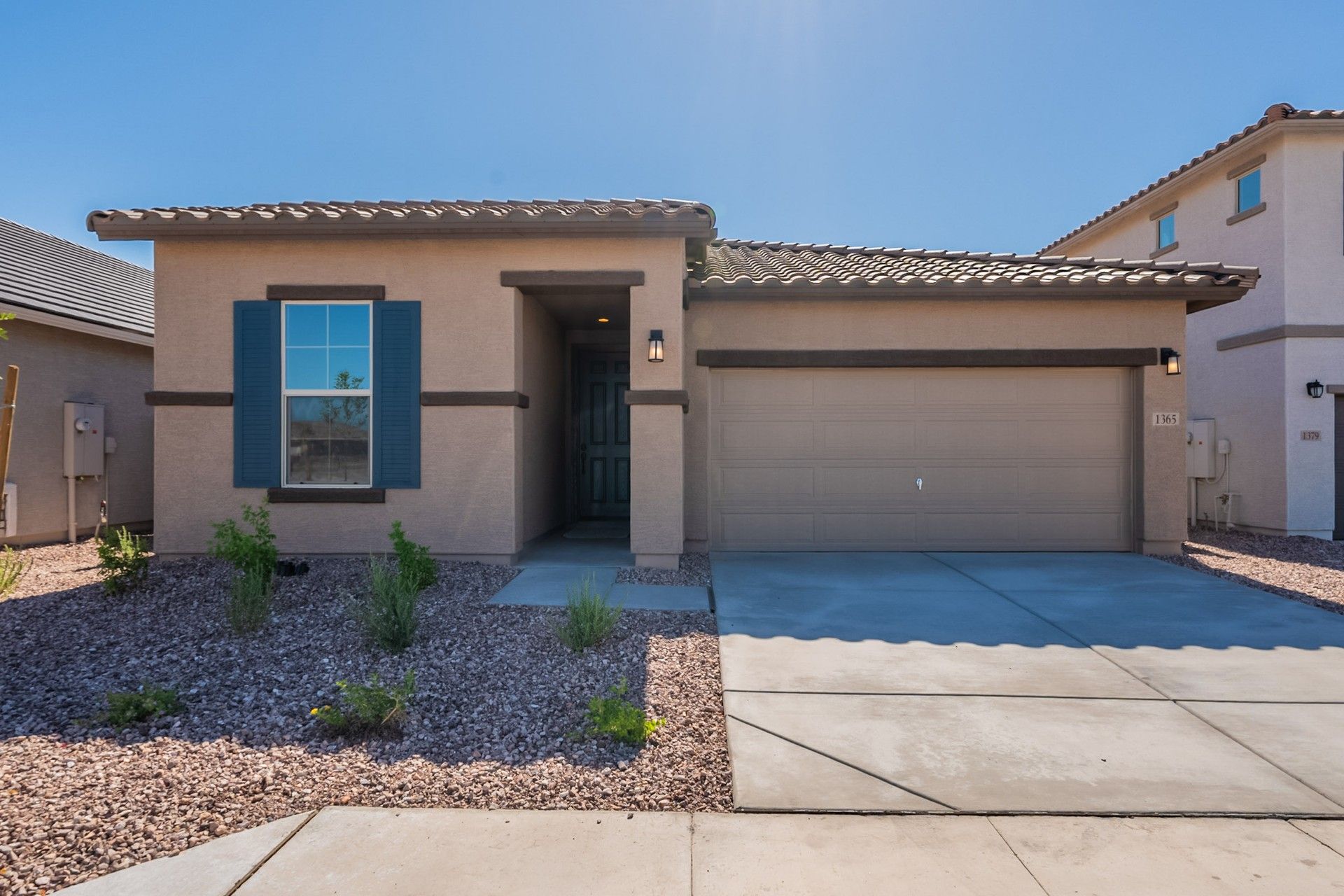 Modern Desert Home with Clay Tile Roof in Sienna Park:Experience elegant stucco design with a classic clay tile roof amidst serene desert landscaping in Sienna Park.