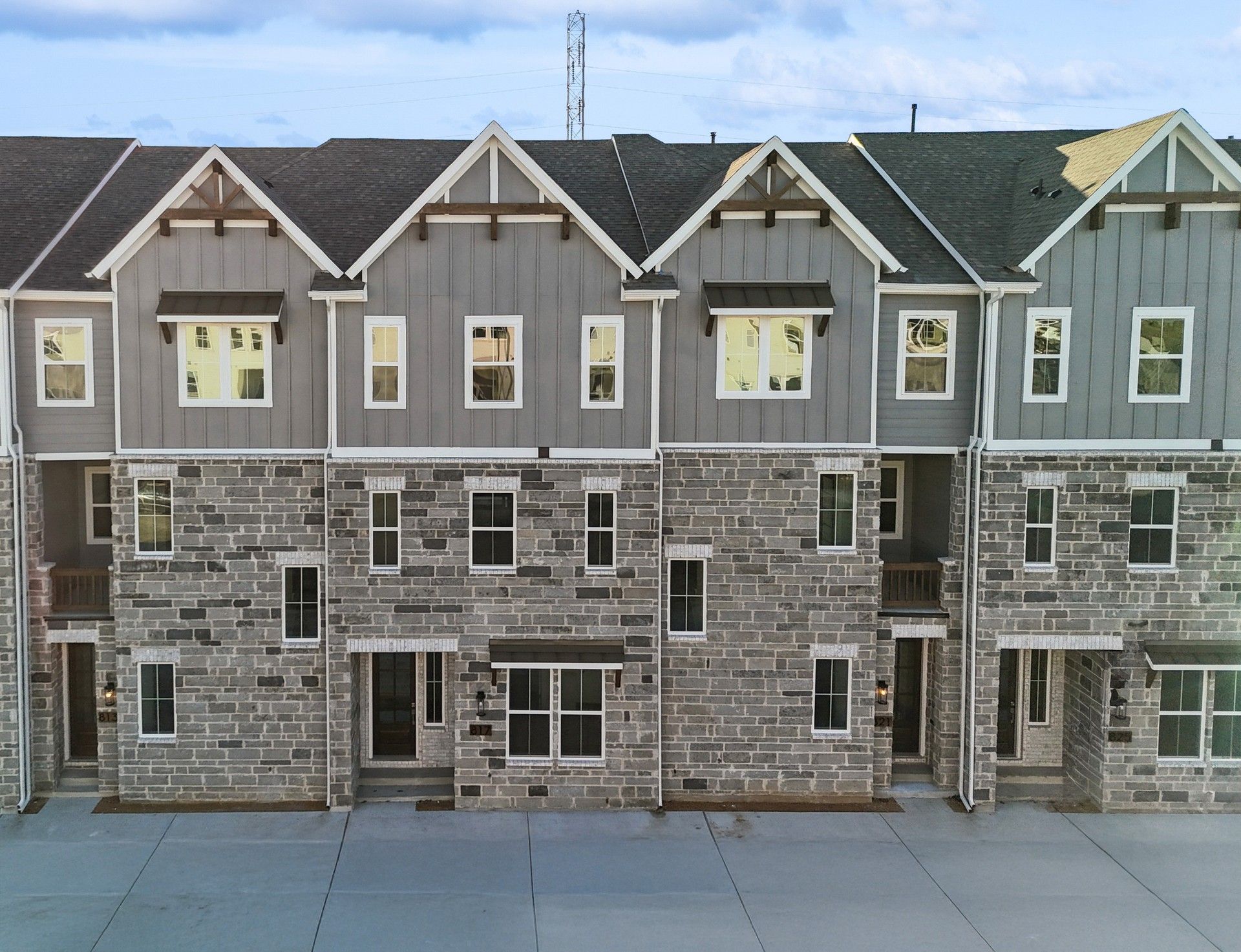 Modern Townhouse at Collin Creek with Stone and Wood Facade:Luxury townhouse in Collin Creek features stone facade, elegant wood accents, steep gable roofs for refined living.