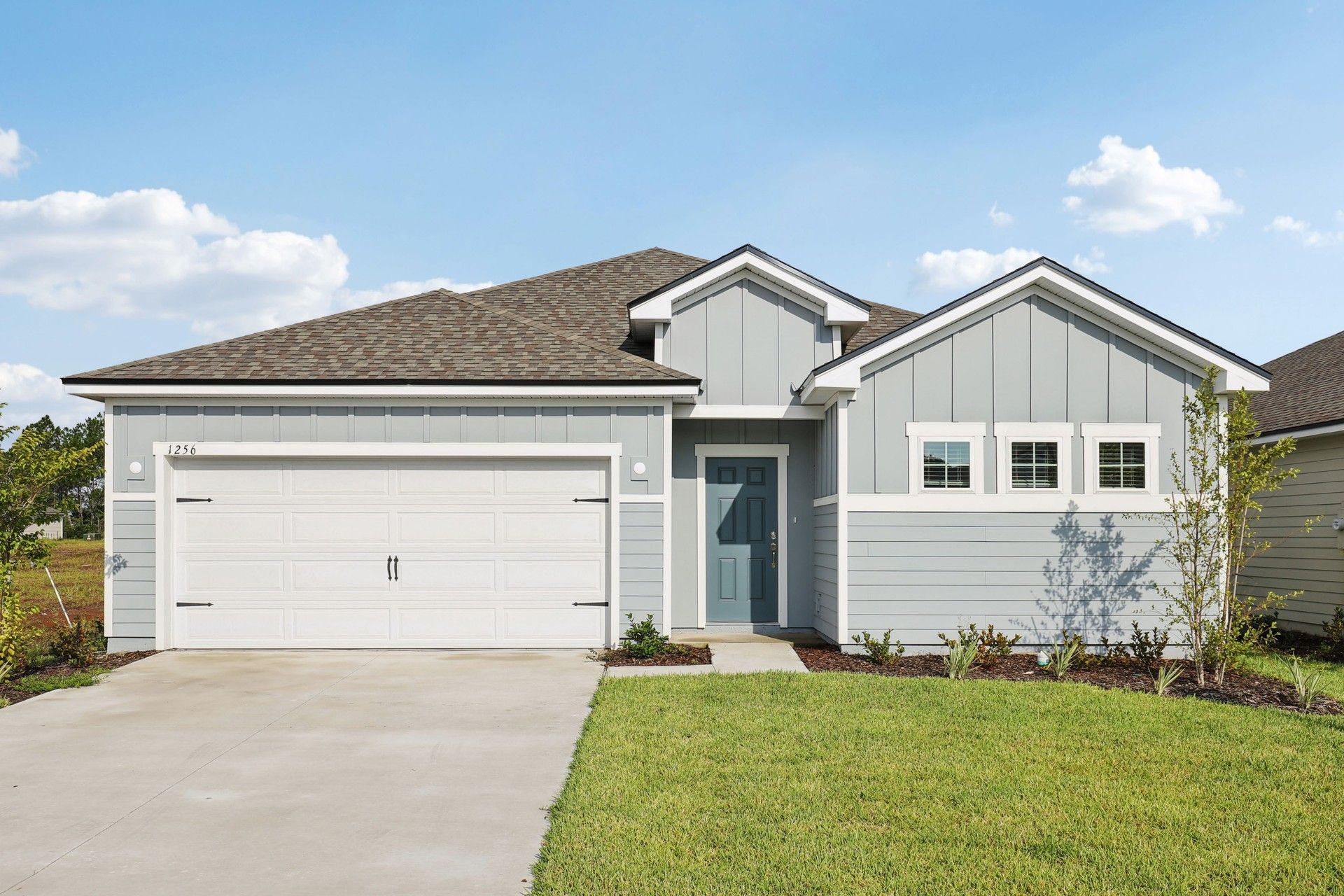 Contemporary Single-Story Home with Garage in Flagler at Panther Creek:Elegant gable roof and chic grey facade define this stylish Panther Creek residence's modern allure.
