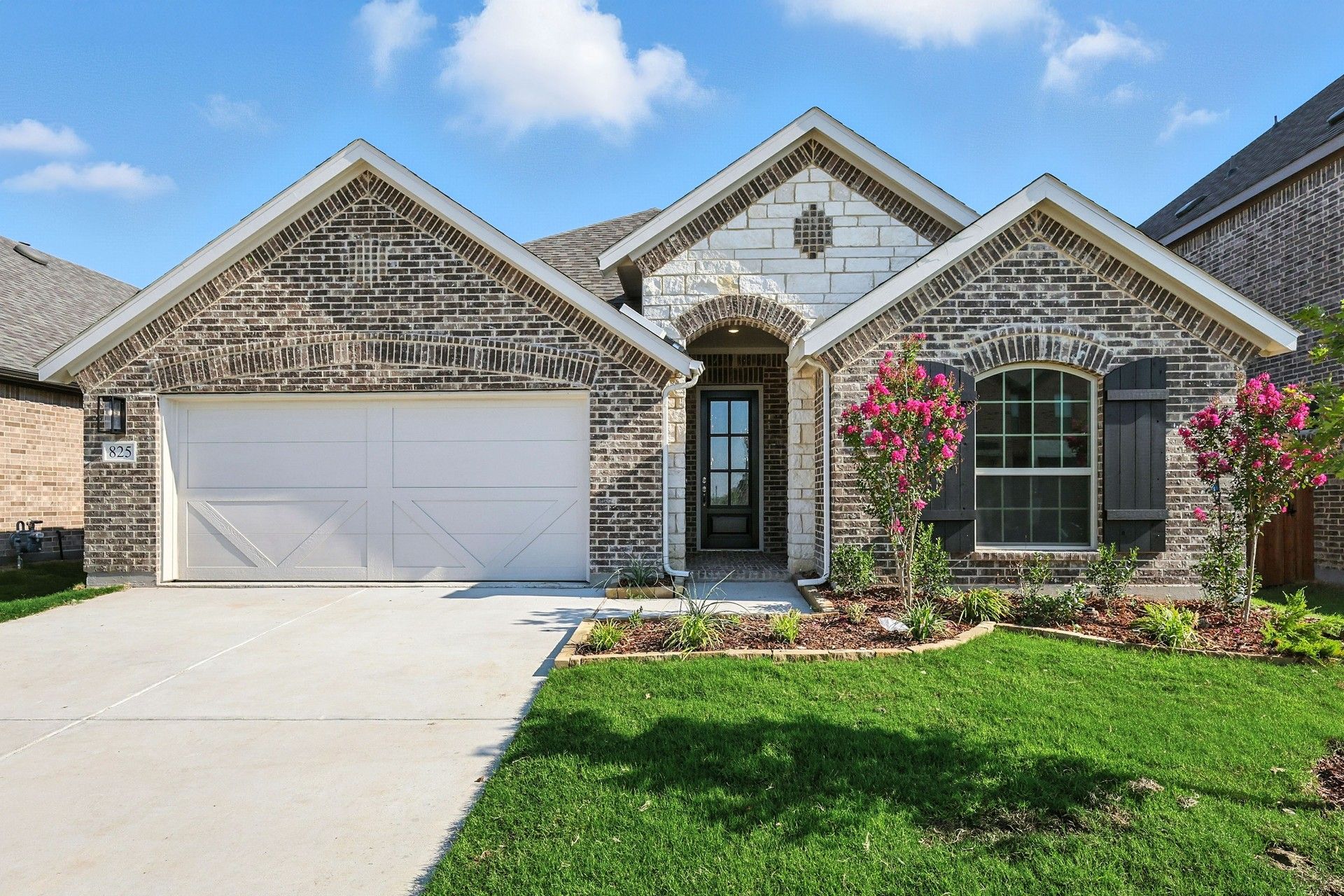 Stone House with Arched Windows and Garage at The Oaks:Distinguished brick facade and lush landscaping, this residence in The Oaks exemplifies architectural elegance.