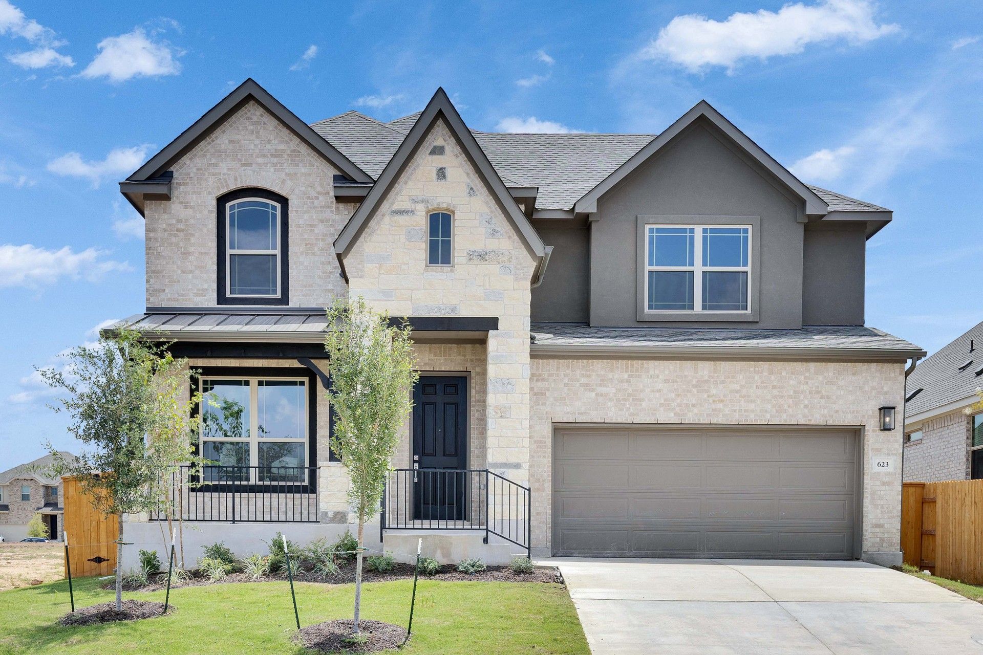 Oaks at San Gabriel two-story home in Georgetown, Texas:Luxurious stone facade with wood accents defines this elegant Georgetown residence at Oaks at San Gabriel.