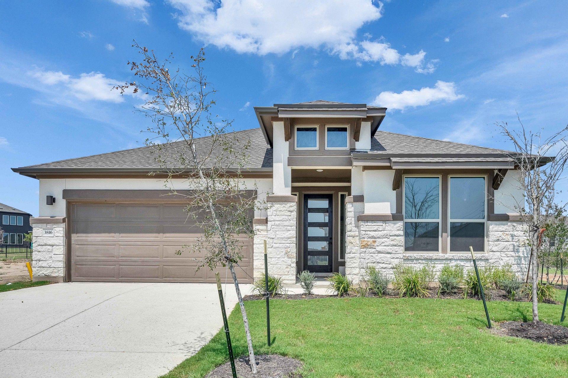 Modern Stone Facade Home at Preserve at Lakeside Meadows:Impeccable stonework and sleek design define this home's elegant facade in Preserve at Lakeside Meadows.