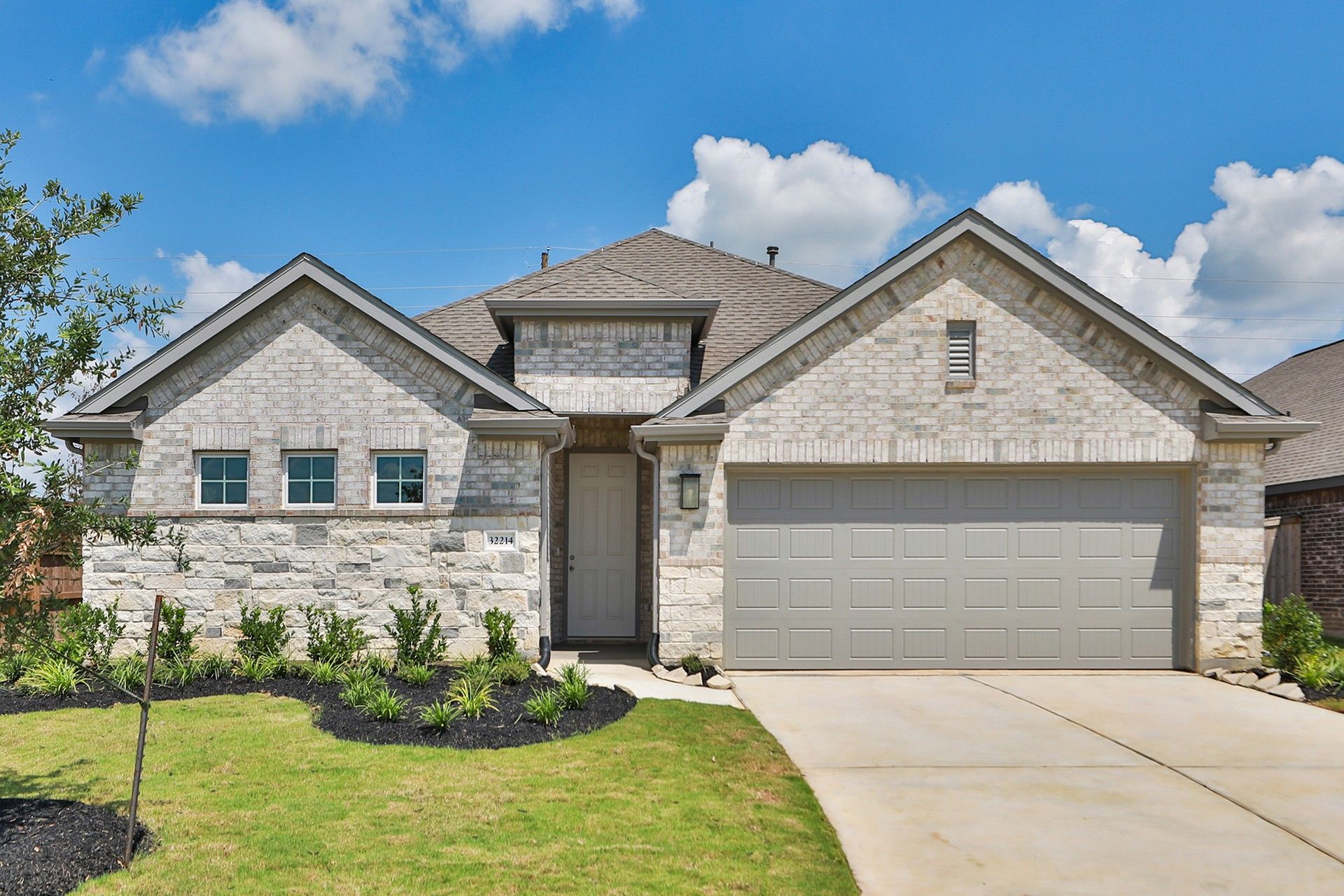 Modern Single-Story Home with Stone Facade in Oakwood Estates:Luxurious Oakwood Estates home boasts stone facade, gabled roof, and pristine landscaping.