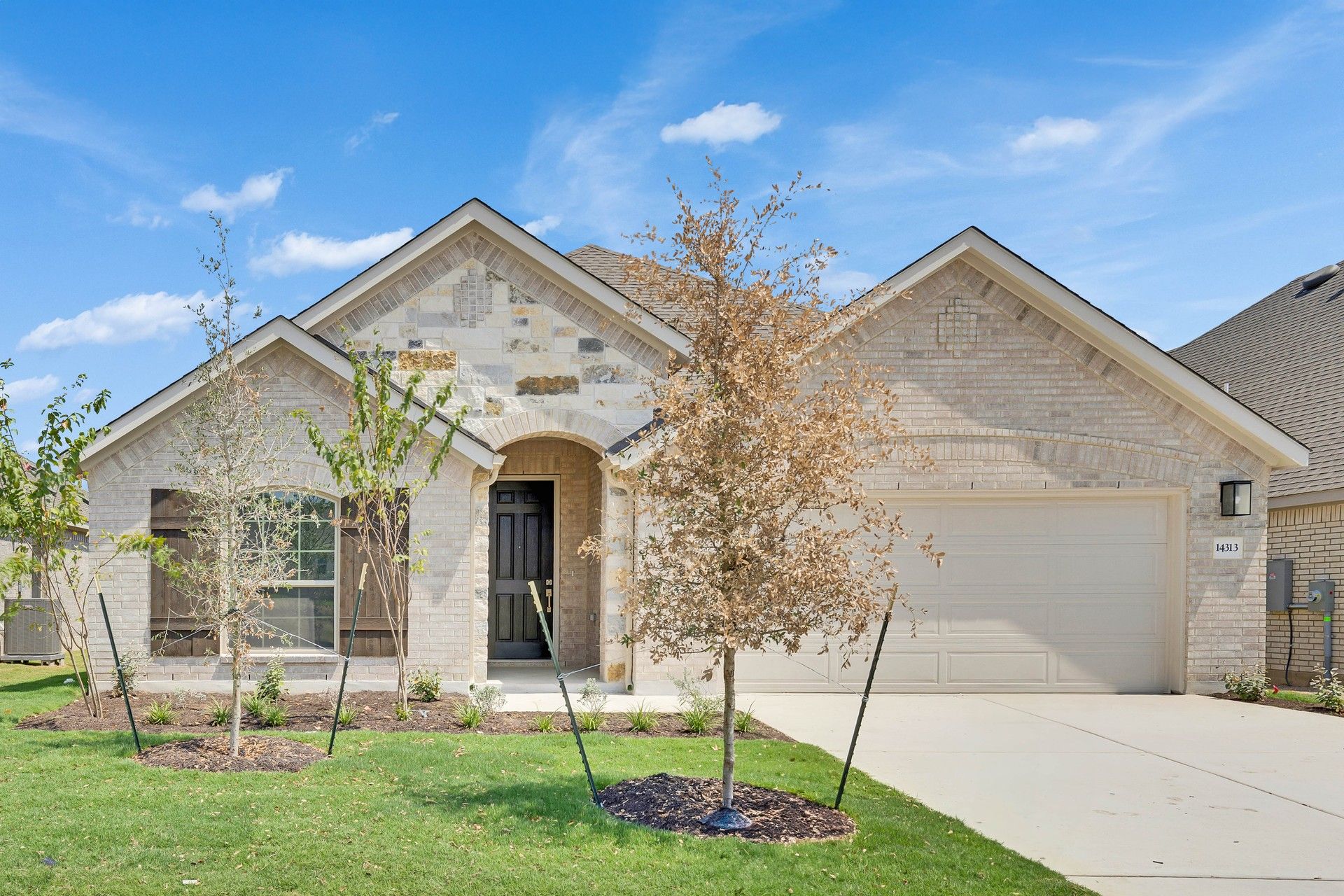 Elegant Brick House with Arched Entry in Carillon:Timeless brick and stone facade with arched details and stylish wooden shutters in Carillon area. Elegant landscaping.