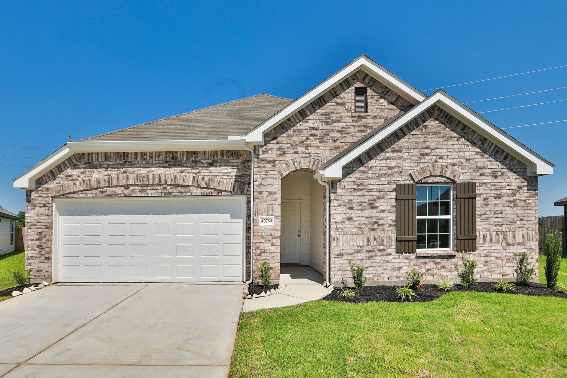 Brick Home in Mostyn Springs, Magnolia, TX - Landmark Avalon Plan:Elegant brick facade with arched entryway in Mostyn Springs, Magnolia, TX.