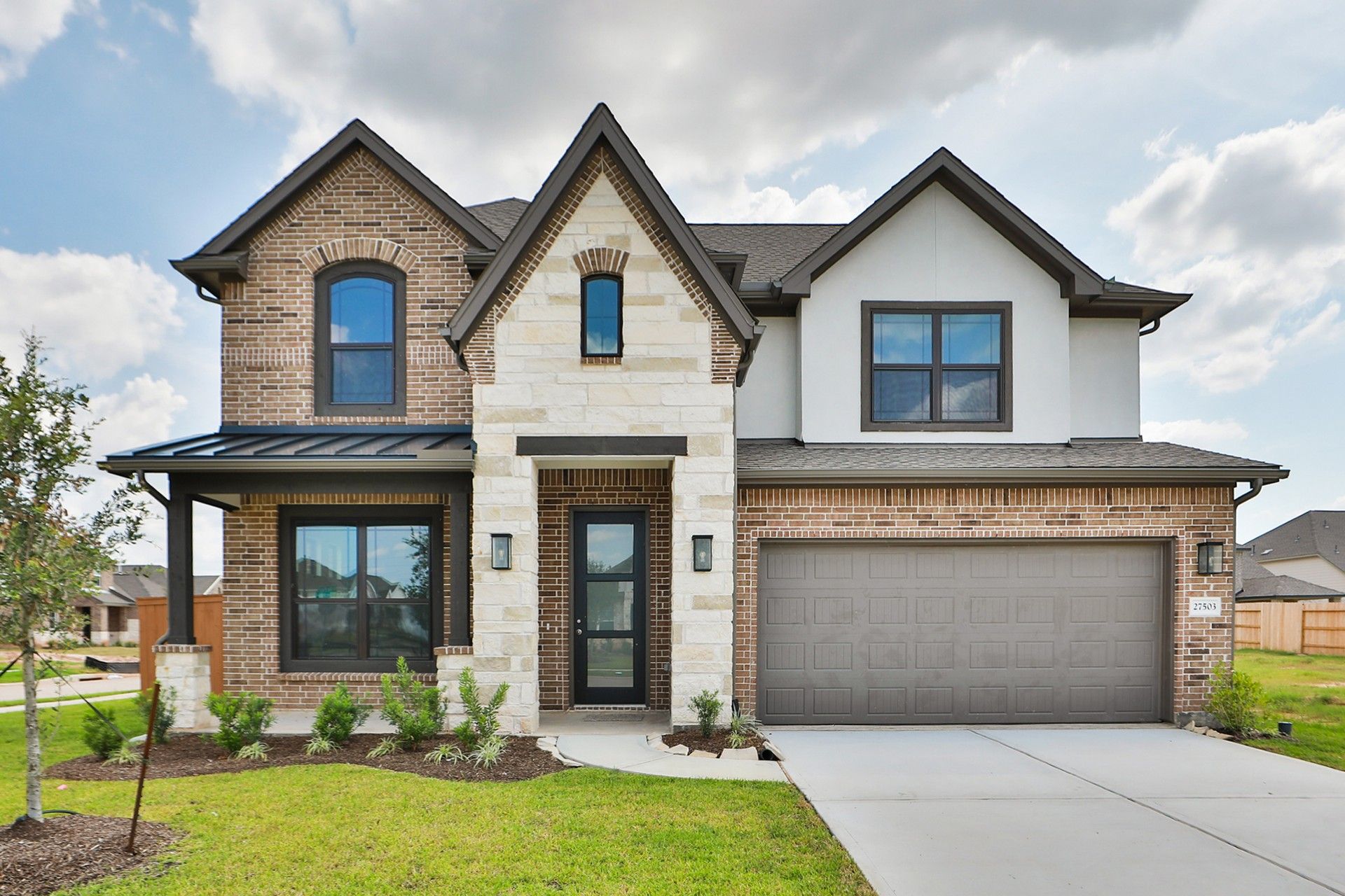 Luxury Two-Story Home with Stone and Brick Facade in Sunterra:Distinctive stone and brick facade, elegant arched windows. Located in Sunterra’s exclusive enclave.