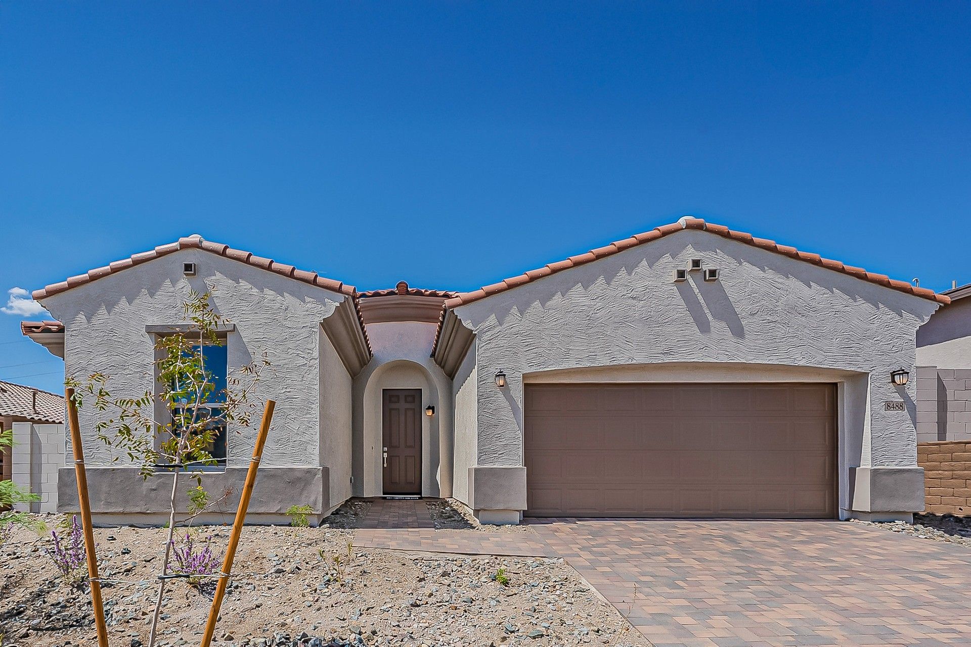 Single-family stucco home with tile roof in Hacienda at Estrella.:Elegant stucco facade and traditional tile roofing grace this Hacienda at Estrella home, exuding timeless charm.