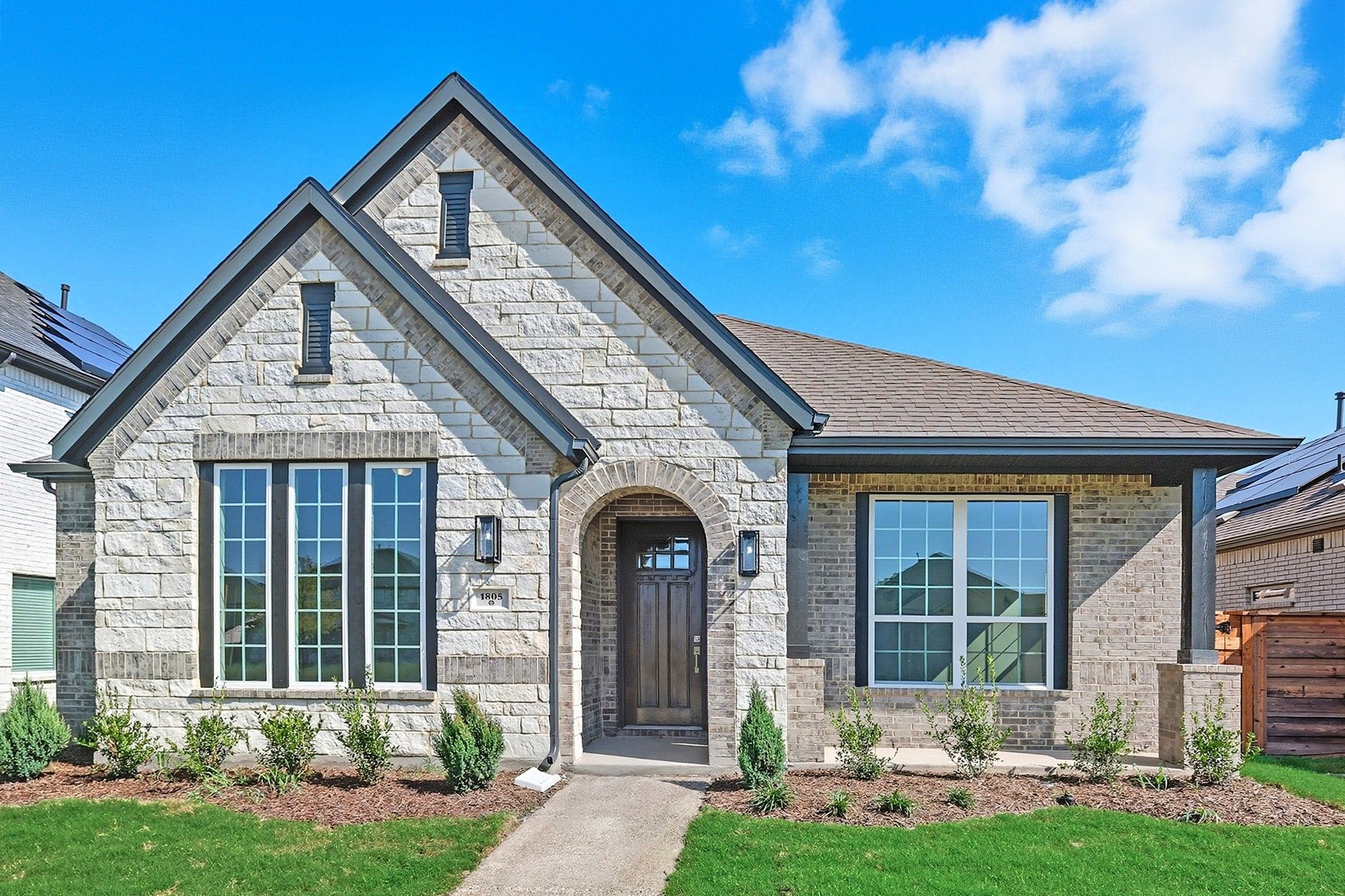 Albany II Home Exterior at 1805 Tree House Trail, Solterra Texas:Sophisticated stonework and expansive windows define this Albany II residence in Solterra, Texas.
