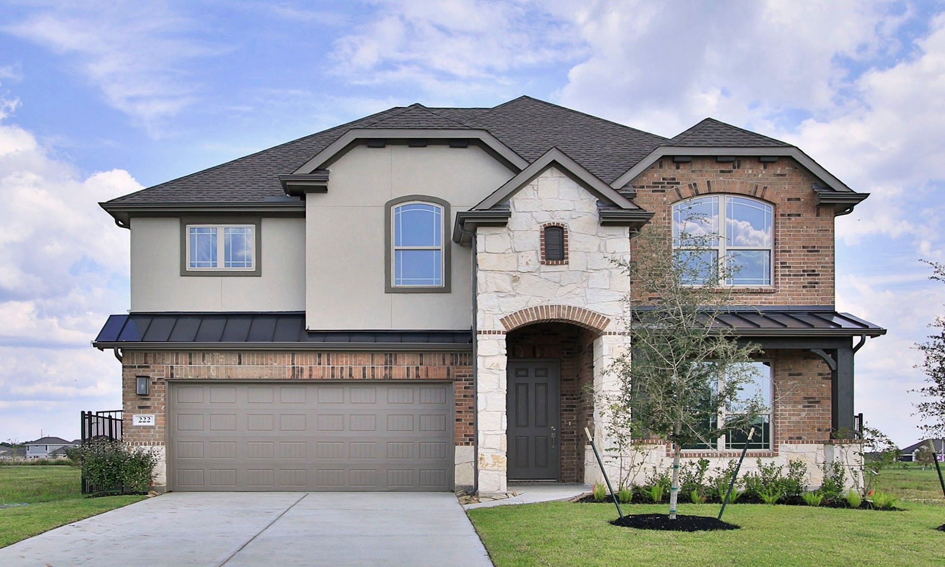 Magnolia at River Ranch Two-Story Brick and Stucco Home:Elegant stone and stucco facade with designer gabled roof, nestled in Magnolia at River Ranch, Texas.