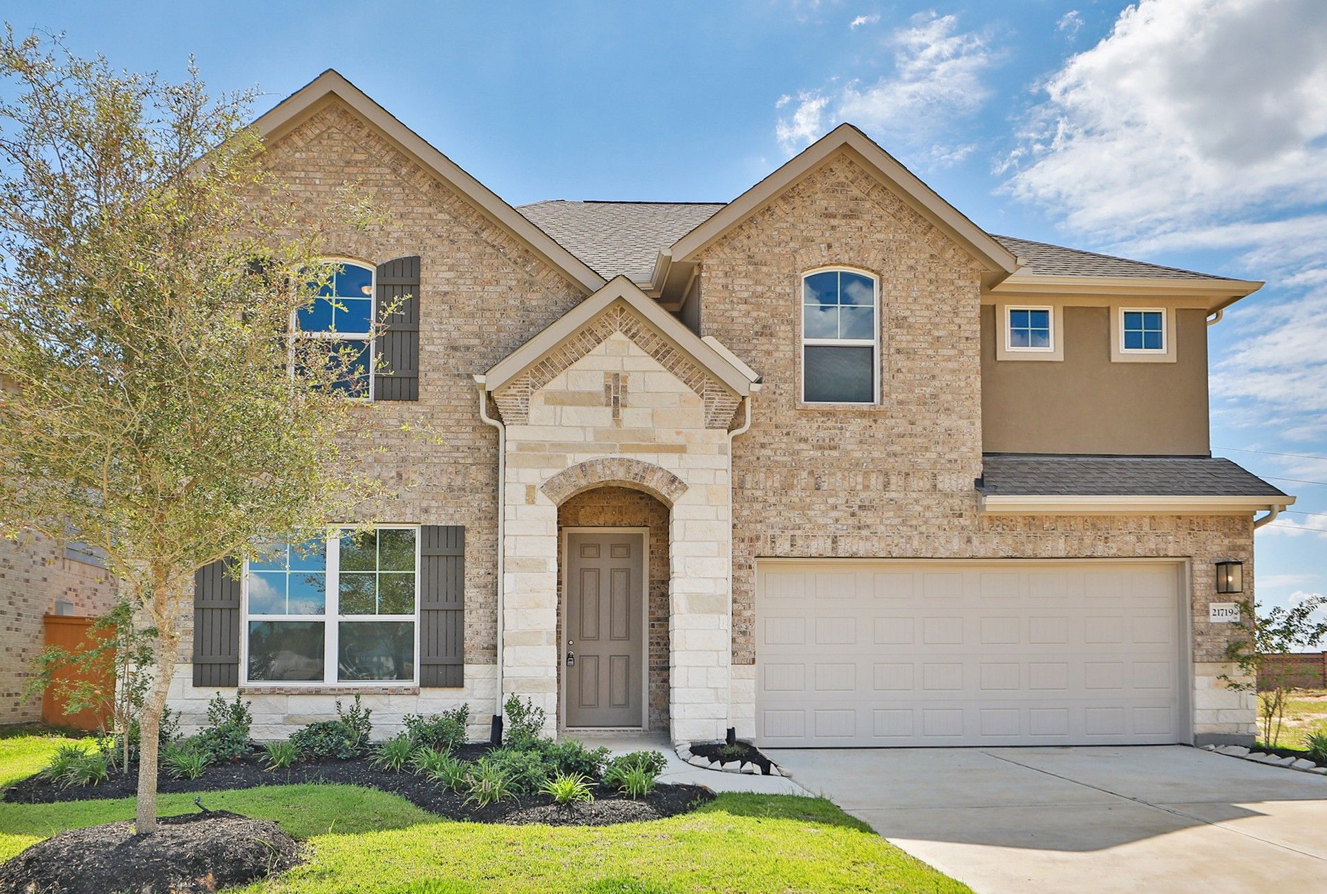 Two-story brick home at 21719 Paphos Drive in Cypress Green:Stunning brick facade with arched entry and lush landscaping at 21719 Paphos Drive, Cypress Green.