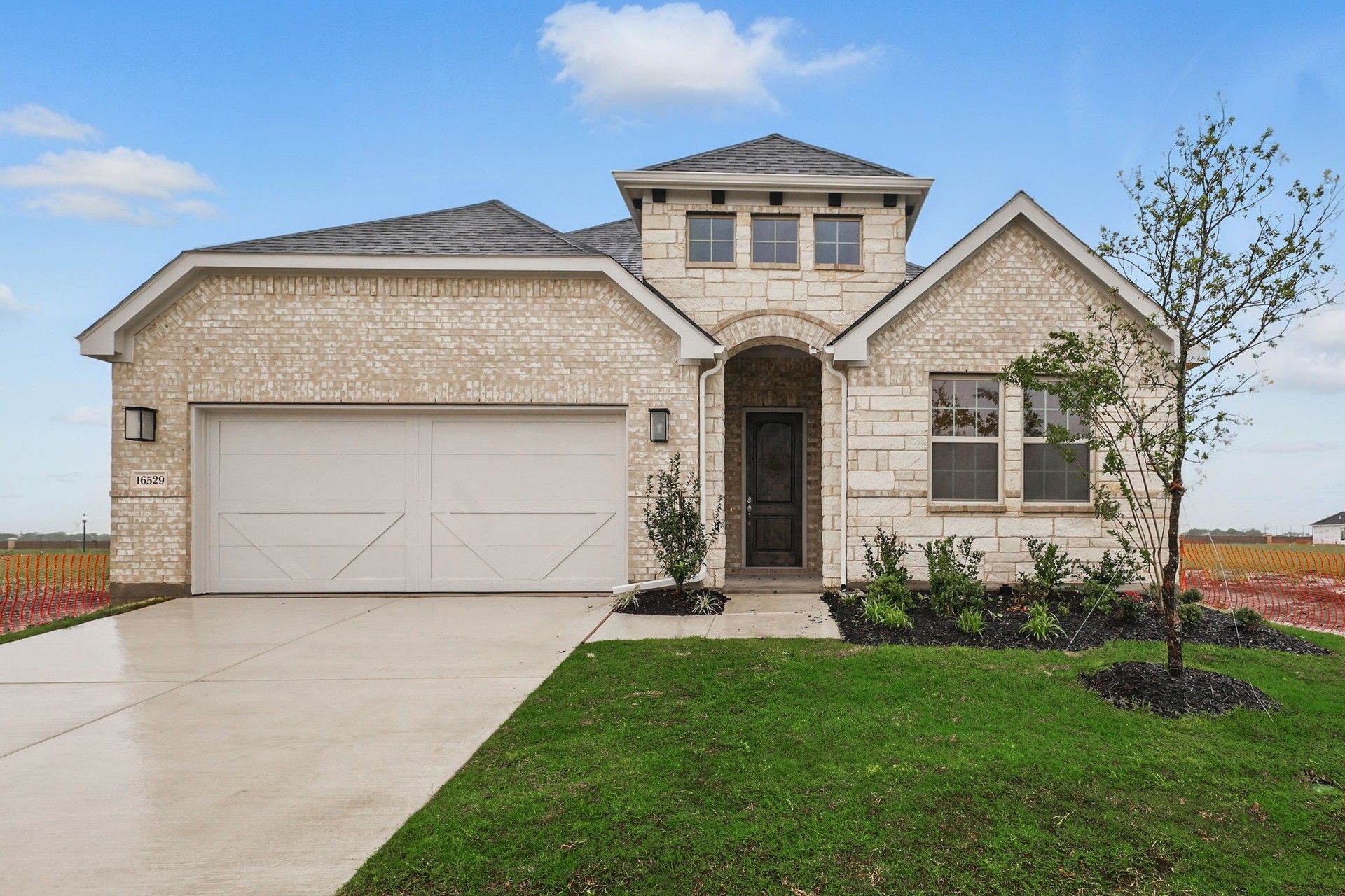 Green Meadows Juniper Plan Home at 16529 Freshwater Drive:Luxurious brick exterior with arched entryway in Green Meadows' Juniper plan.
