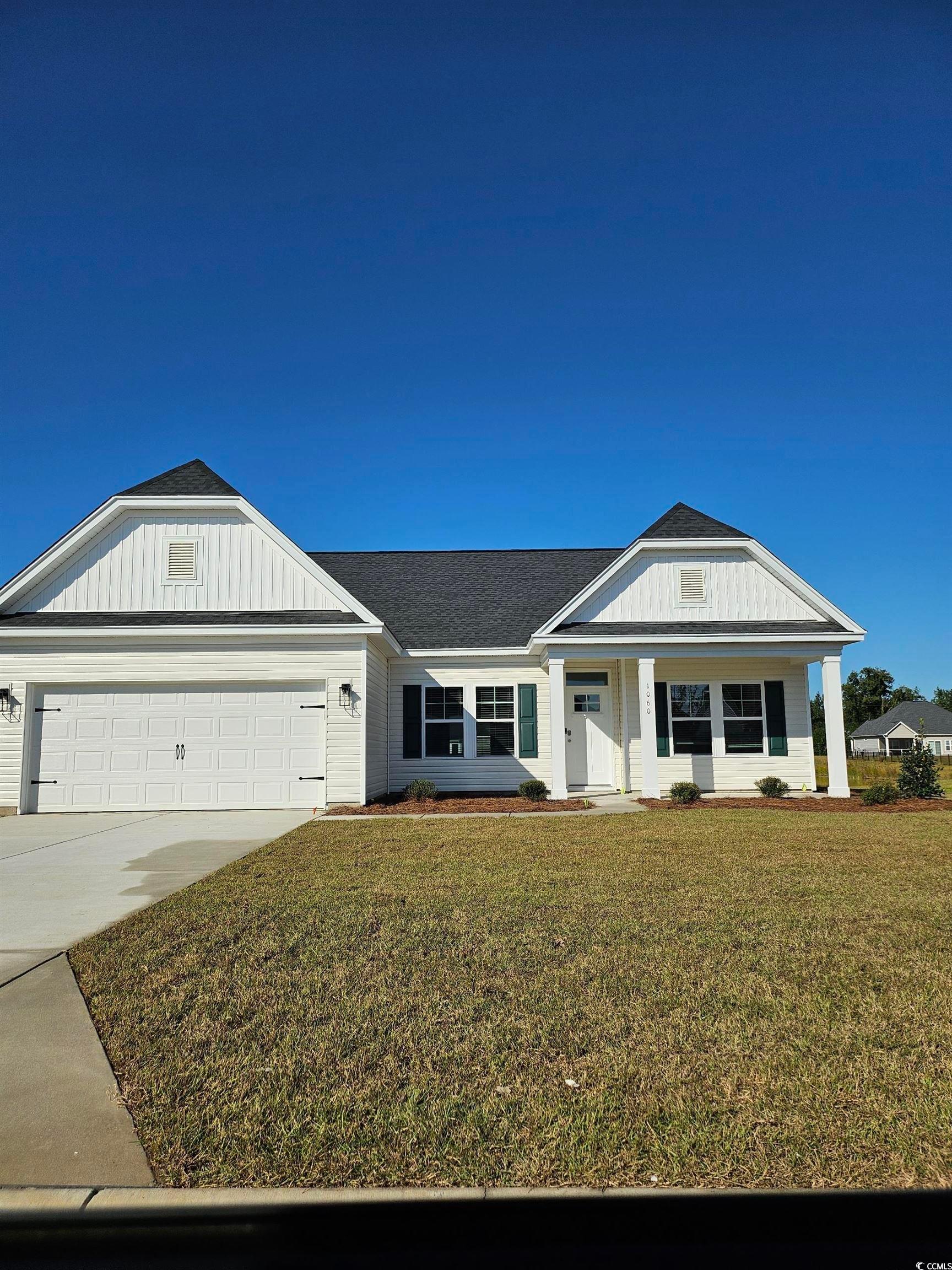 Exterior:View of front of house featuring covered porch, driveway, an attached garage, a front yard, and roo