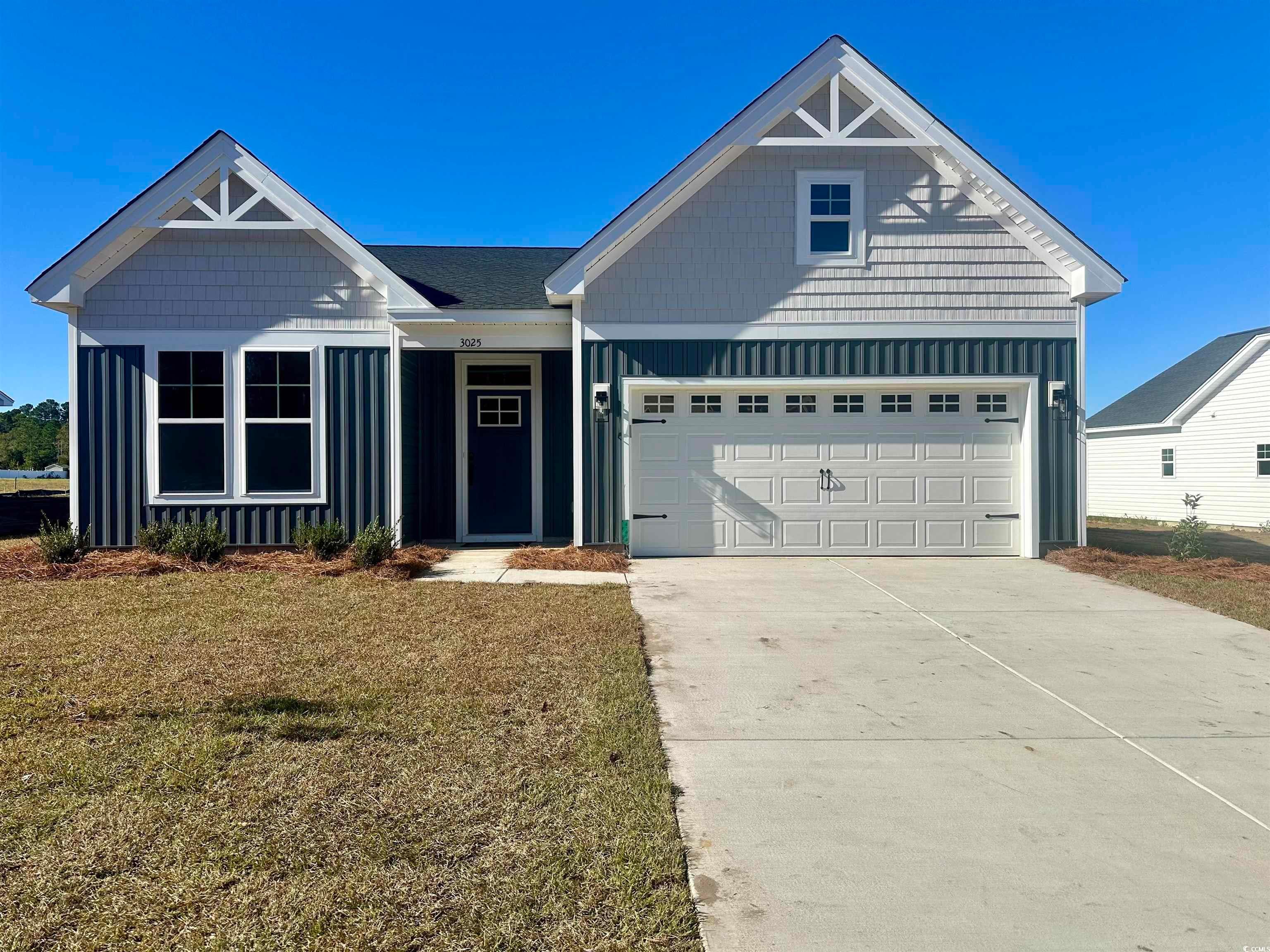 Exterior:View of front of home featuring board and batten siding, concrete driveway, and a front yard