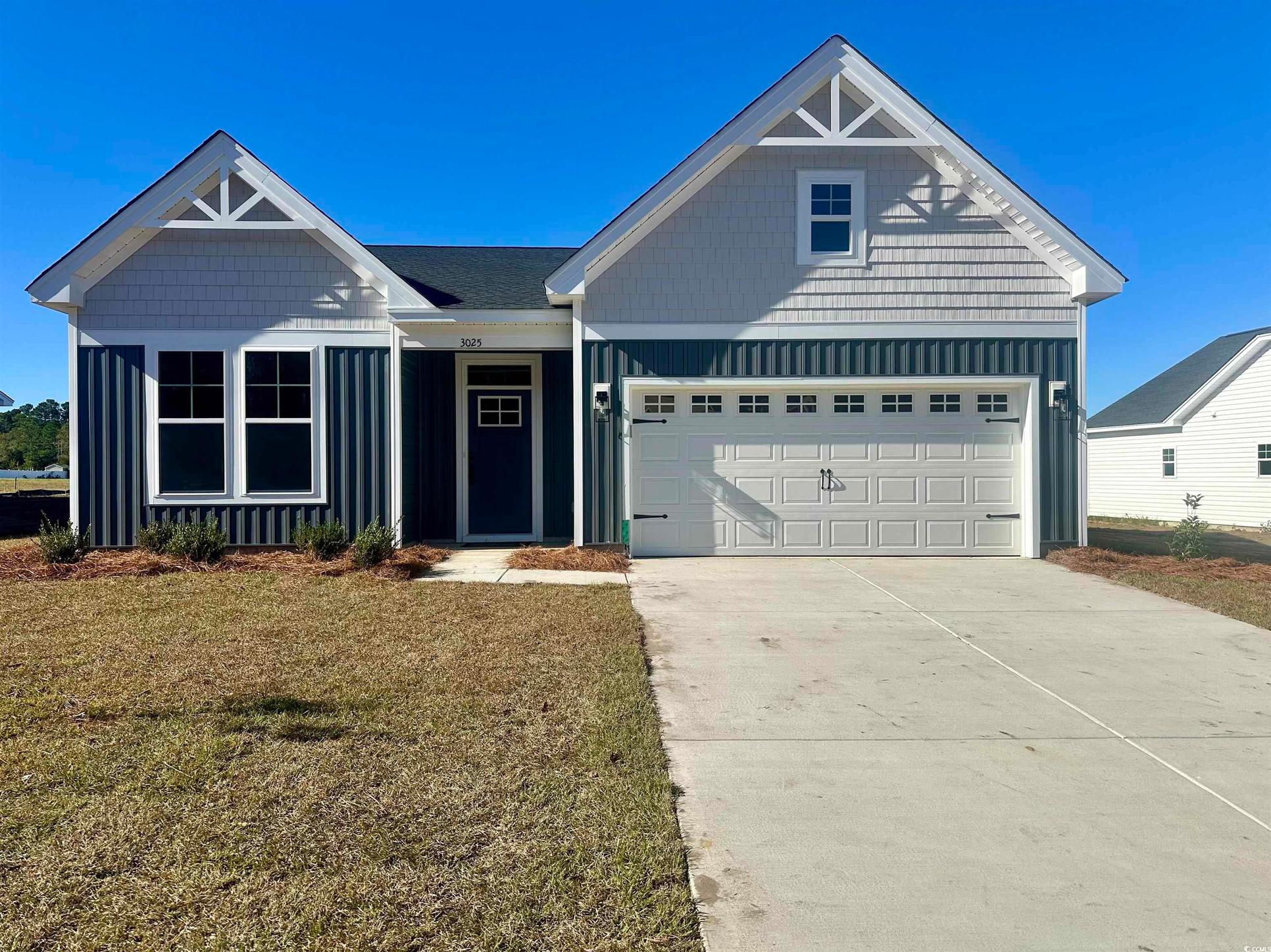 Exterior:View of front of home featuring board and batten siding, concrete driveway, and a front yard