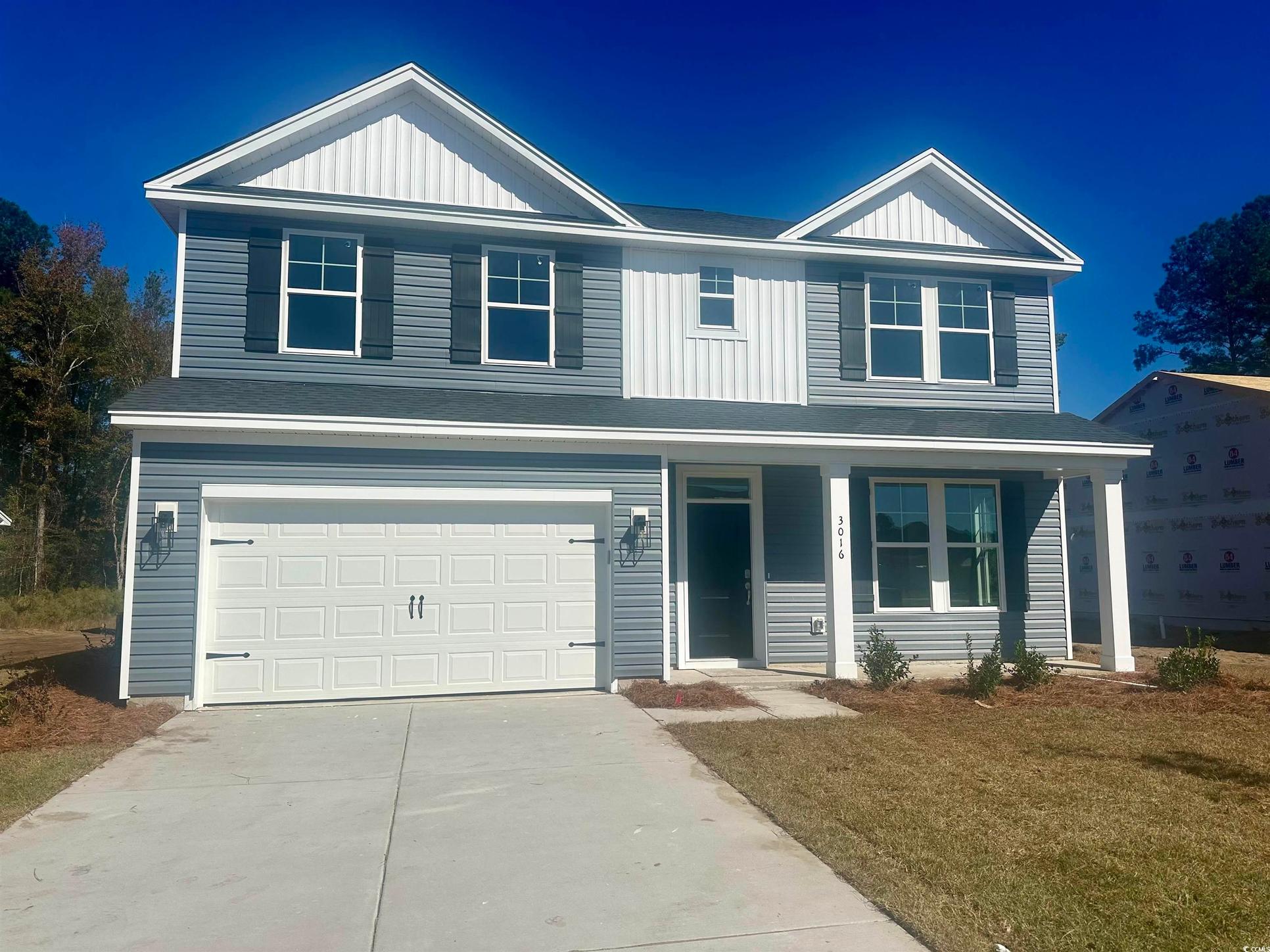 Exterior:Traditional home featuring a garage, board and batten siding, a porch, driveway, and a front lawn
