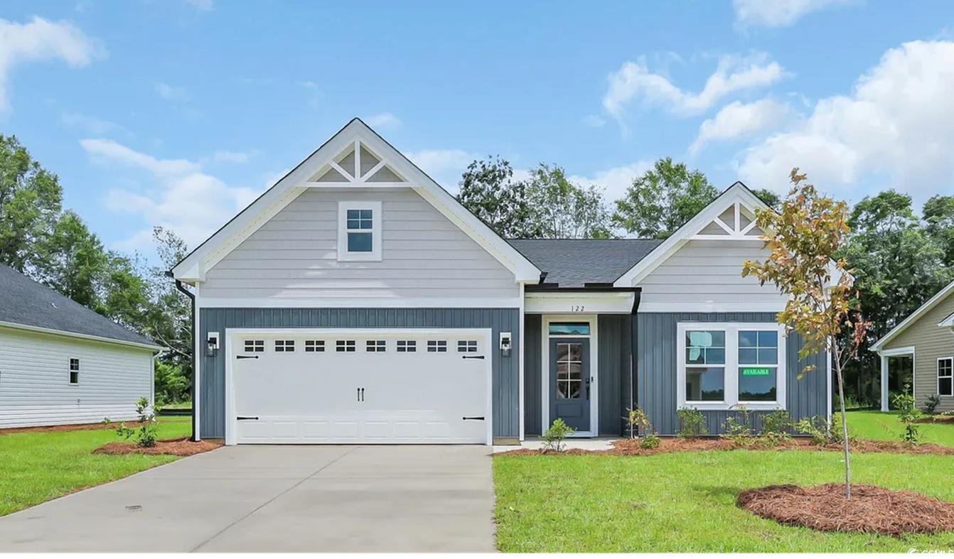 Exterior:View of front facade featuring a front lawn, board and batten siding, and concrete driveway