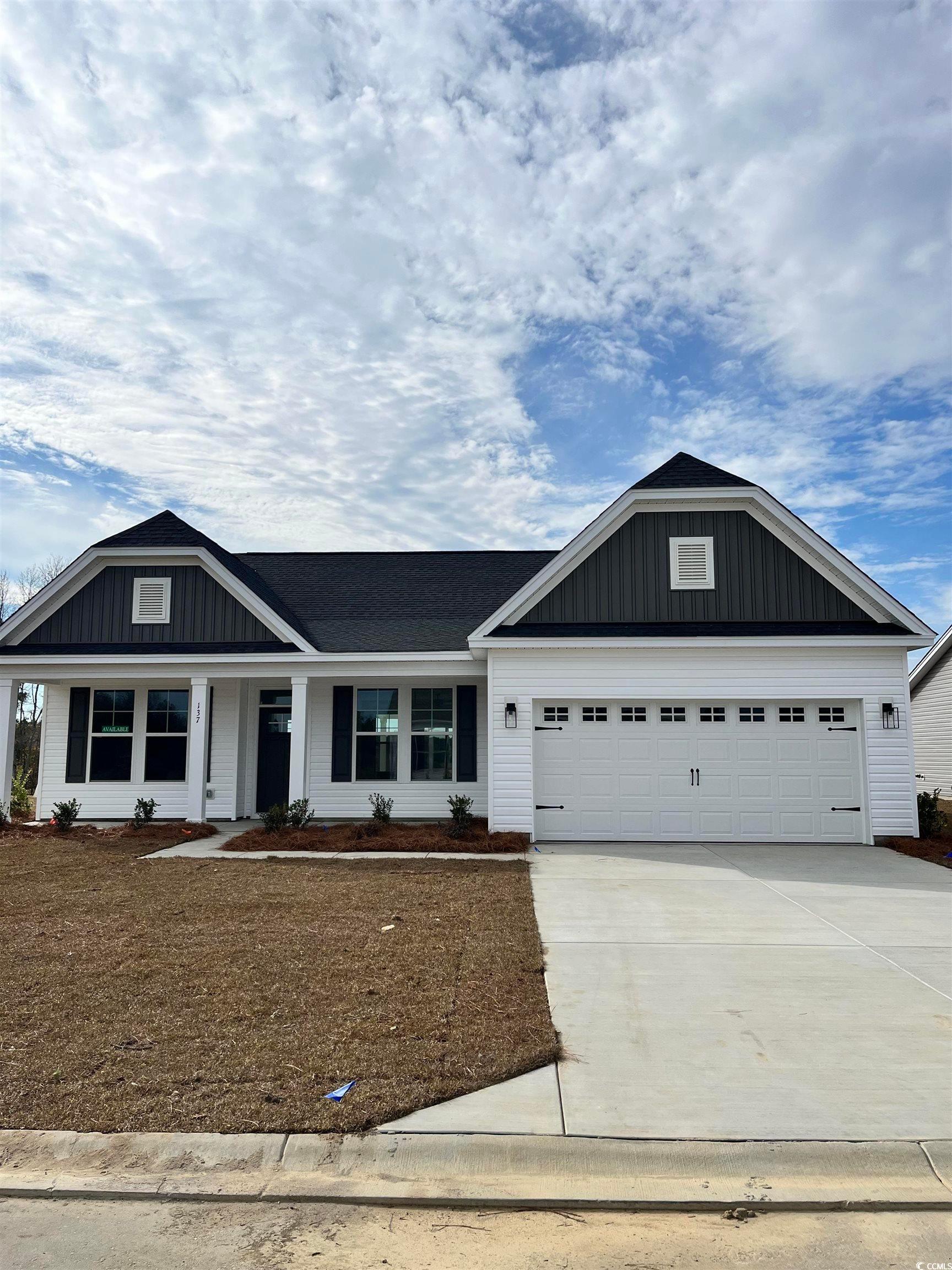 Exterior:View of front of property with a porch, driveway, a garage, and board and batten siding