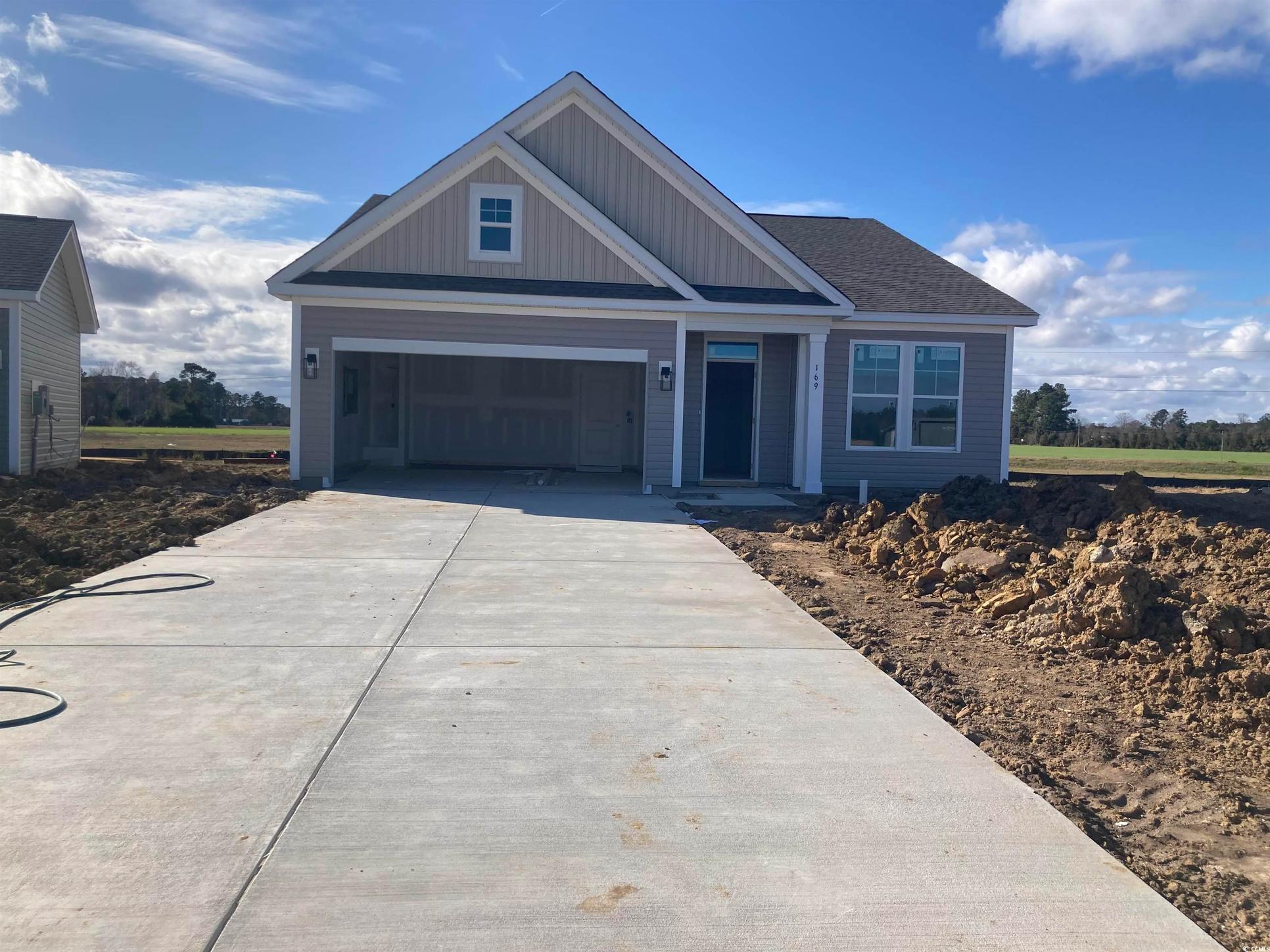 Exterior:View of front of property featuring driveway, a garage, and board and batten siding