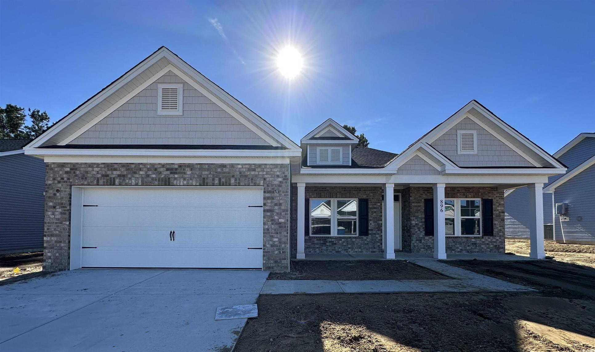 Exterior:Craftsman-style house featuring driveway, covered porch, an attached garage, and brick siding