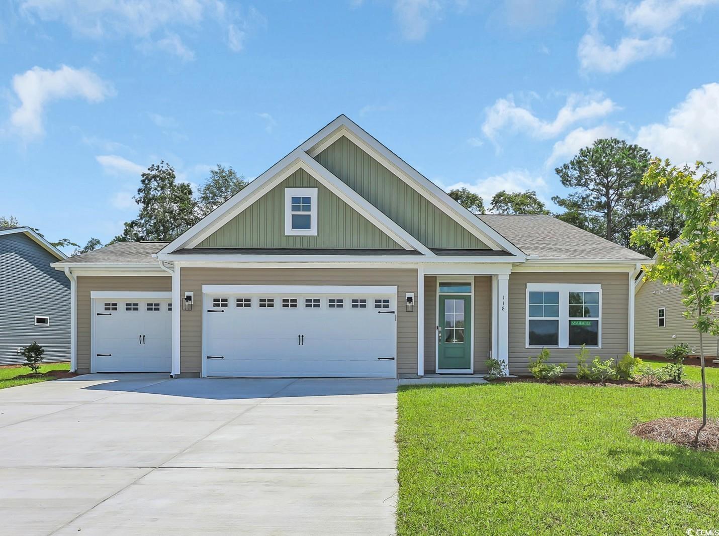 Exterior:View of front of house featuring board and batten siding, concrete driveway, a front lawn, an attac