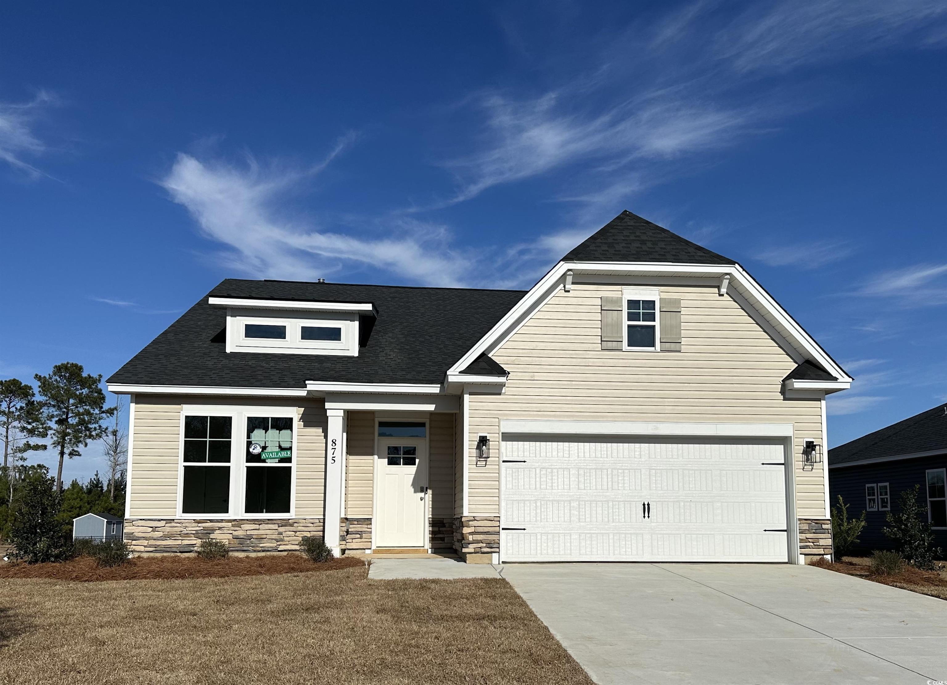 Exterior:View of front of property with stone siding, roof with shingles, concrete driveway, and a front yar