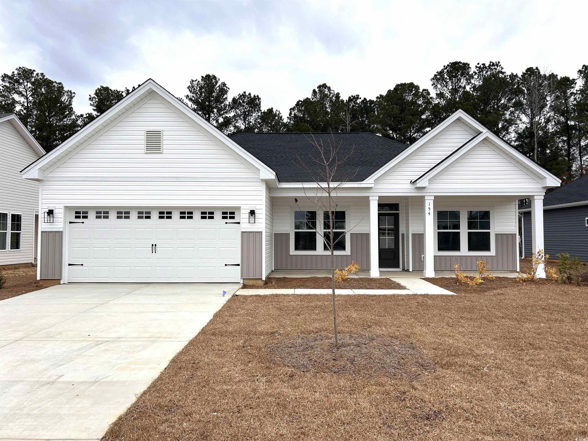 Exterior:Ranch-style home featuring a porch, concrete driveway, board and batten siding, and a garage