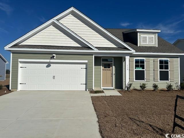 Exterior:View of front of house with driveway, a garage, and a shingled roof