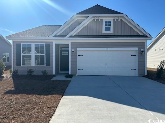 Exterior:View of front of property featuring driveway, a garage, board and batten siding, and a shingled roo