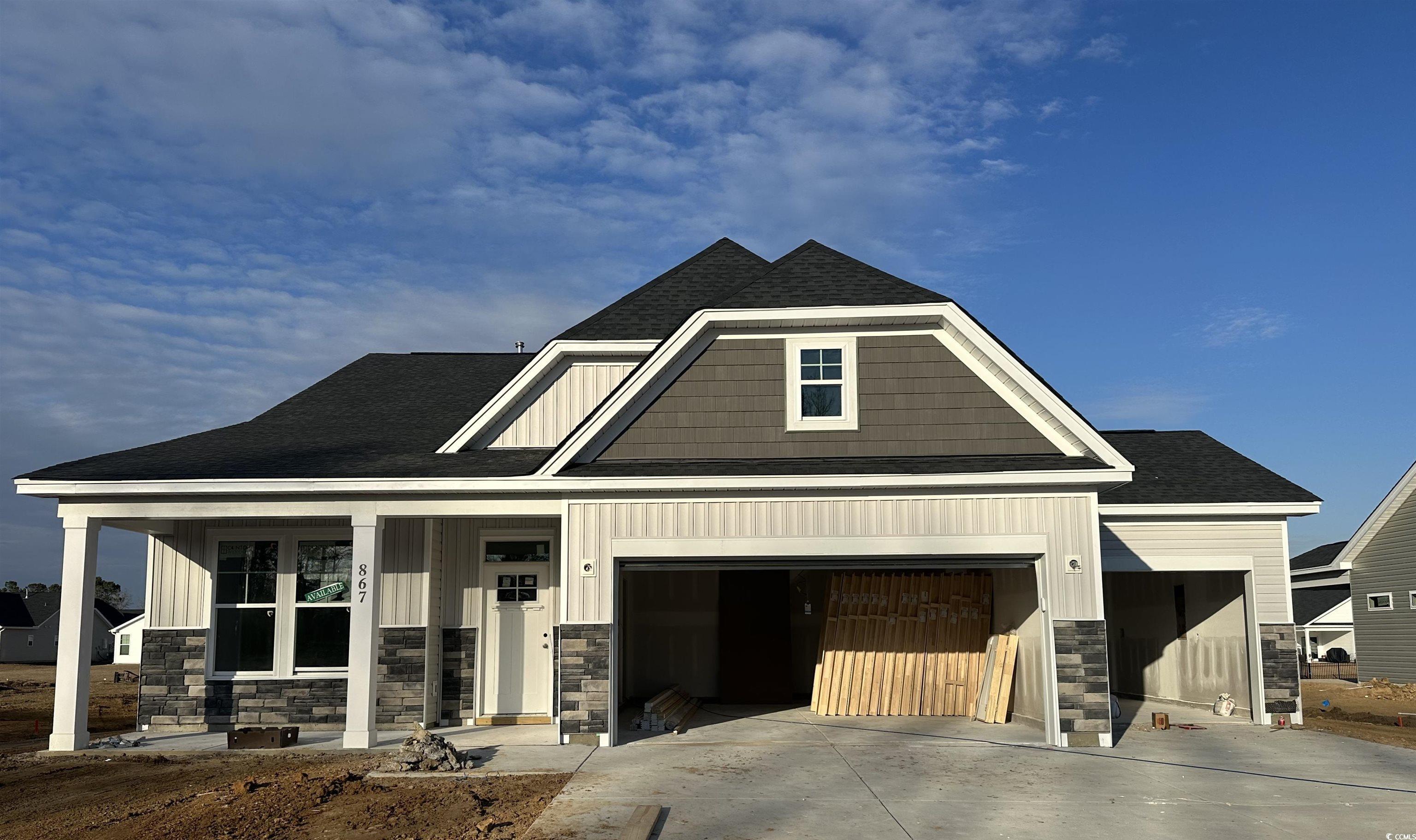 Exterior:Unfinished property with roof with shingles, covered porch, concrete driveway, and board and batten