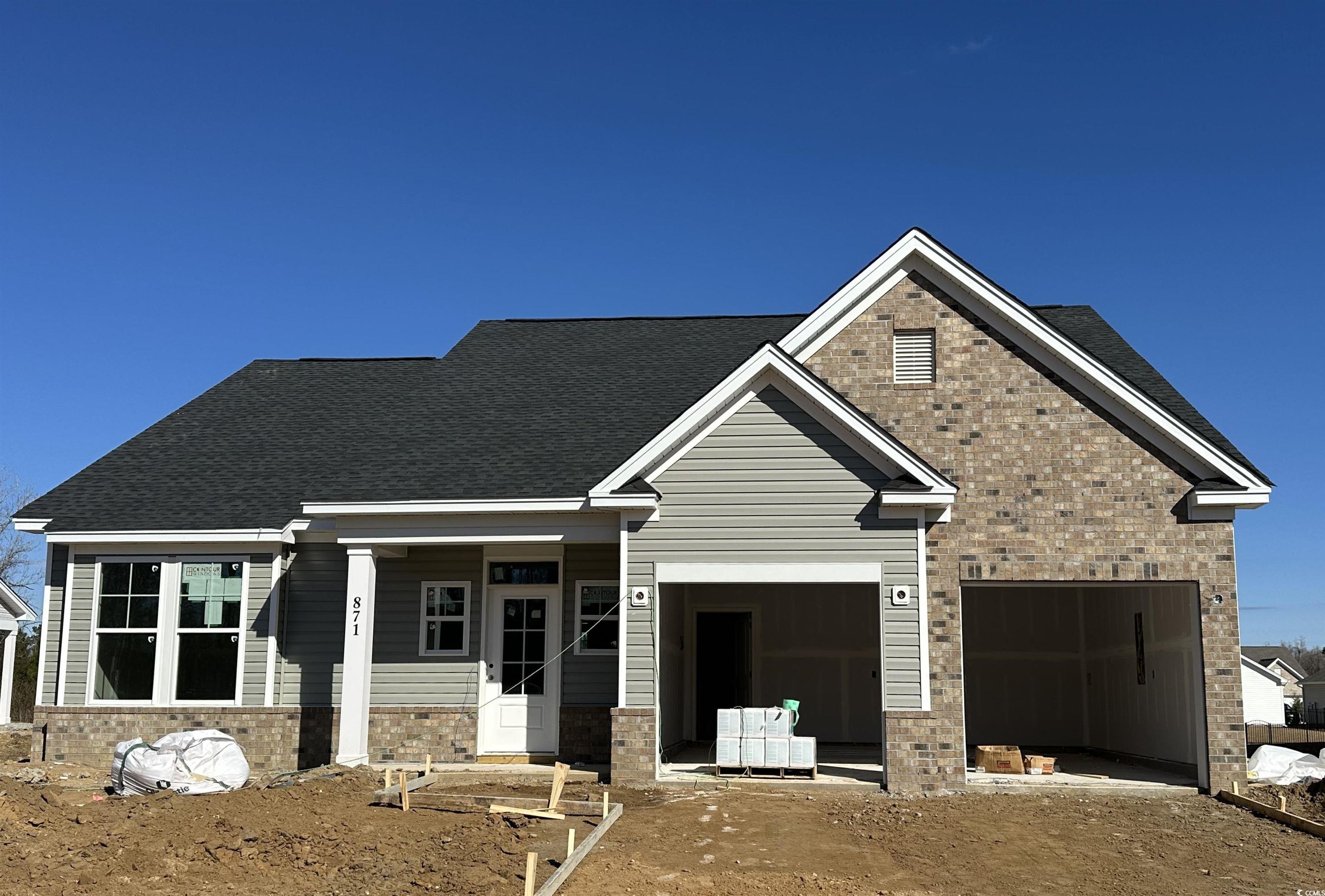 Exterior:View of front of house with covered porch, brick siding, and roof with shingles