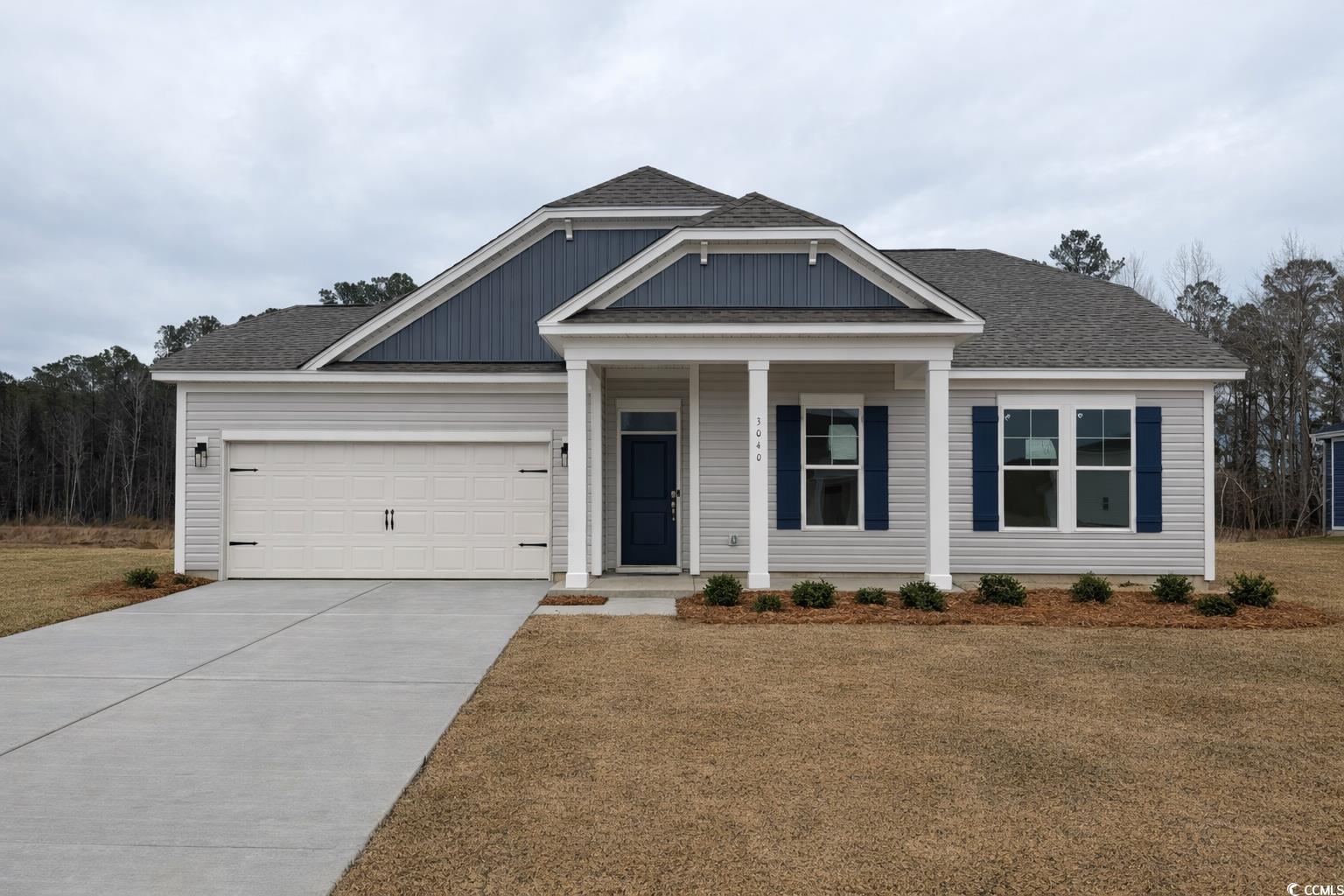 Exterior:Craftsman-style home featuring board and batten siding, a front yard, and concrete driveway
