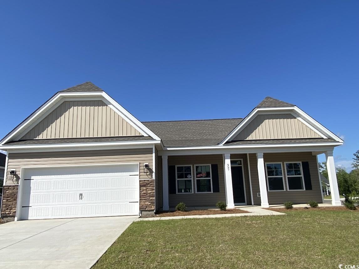 Exterior:View of front of house with concrete driveway, an attached garage, a front lawn, and stone siding