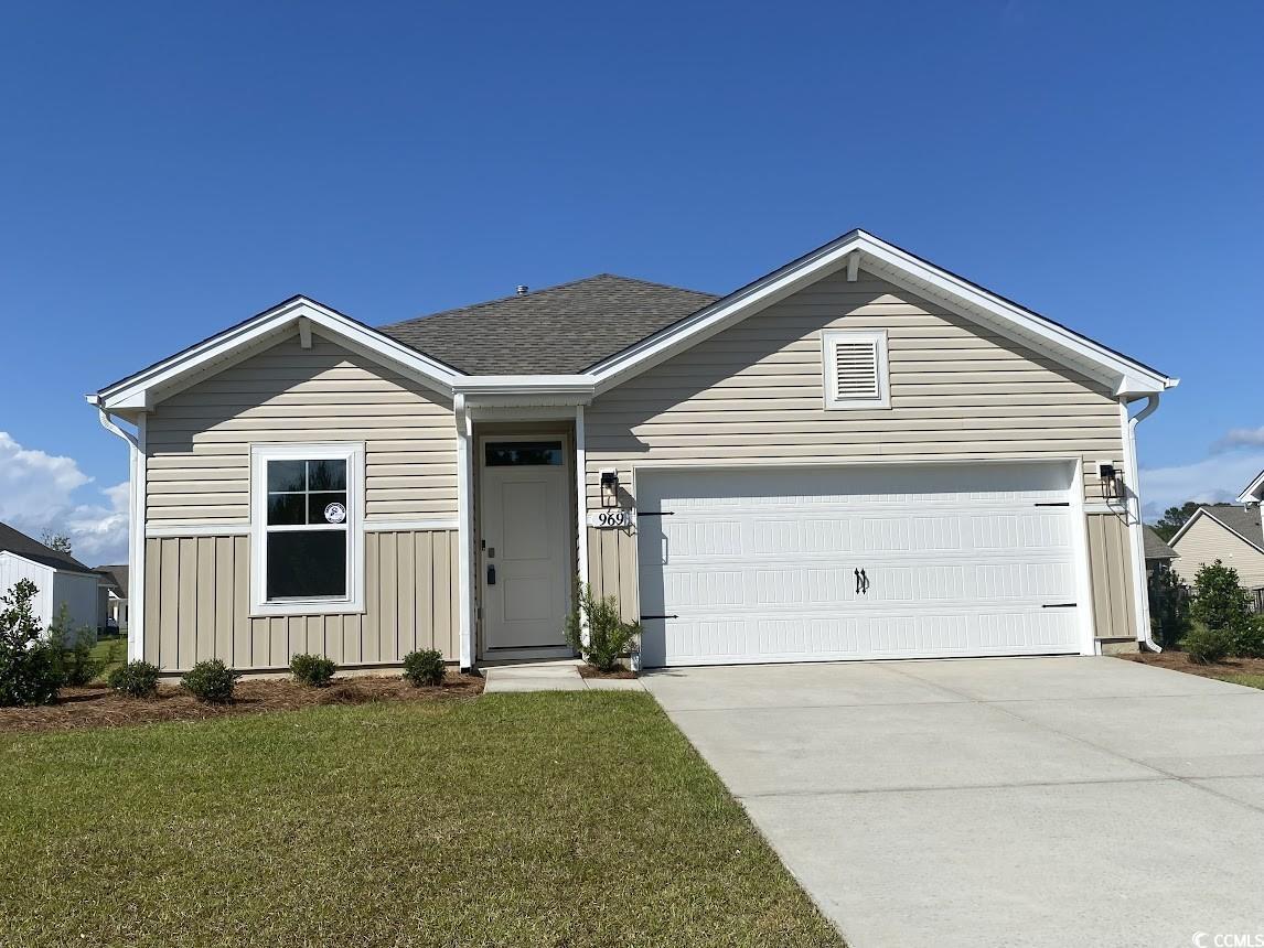 Exterior:Ranch-style house featuring board and batten siding, a garage, a front lawn, and driveway