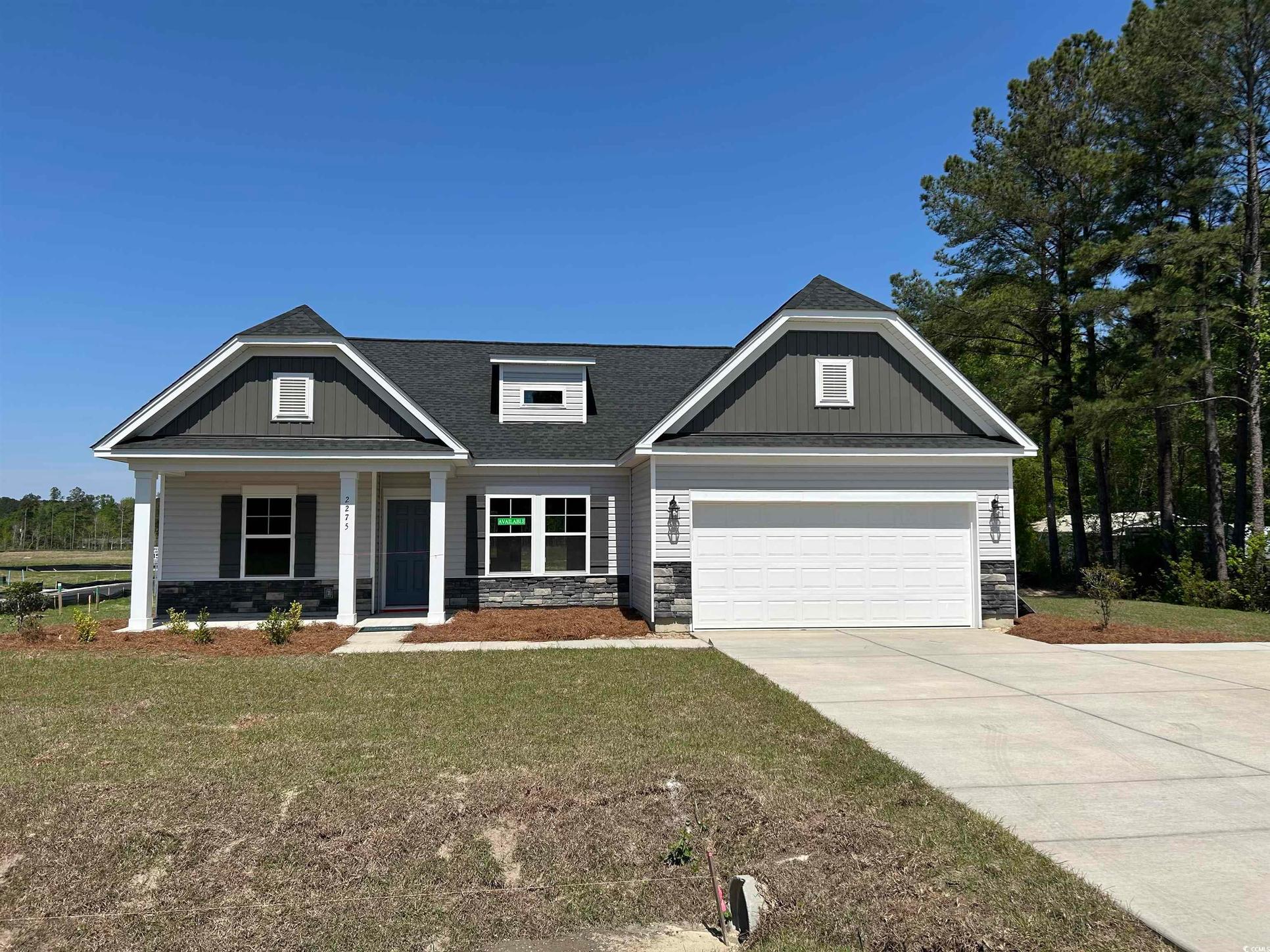 Exterior:Craftsman inspired home with a front yard, a porch, stone siding, a garage, and concrete driveway
