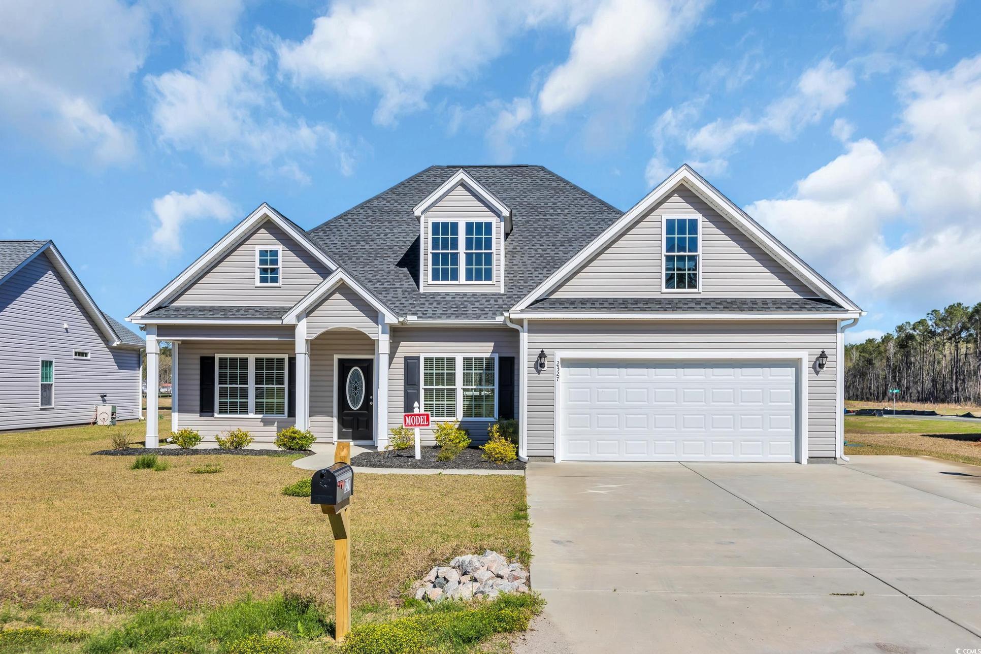 Exterior:View of front facade with a front yard, concrete driveway, a garage, and a shingled roof