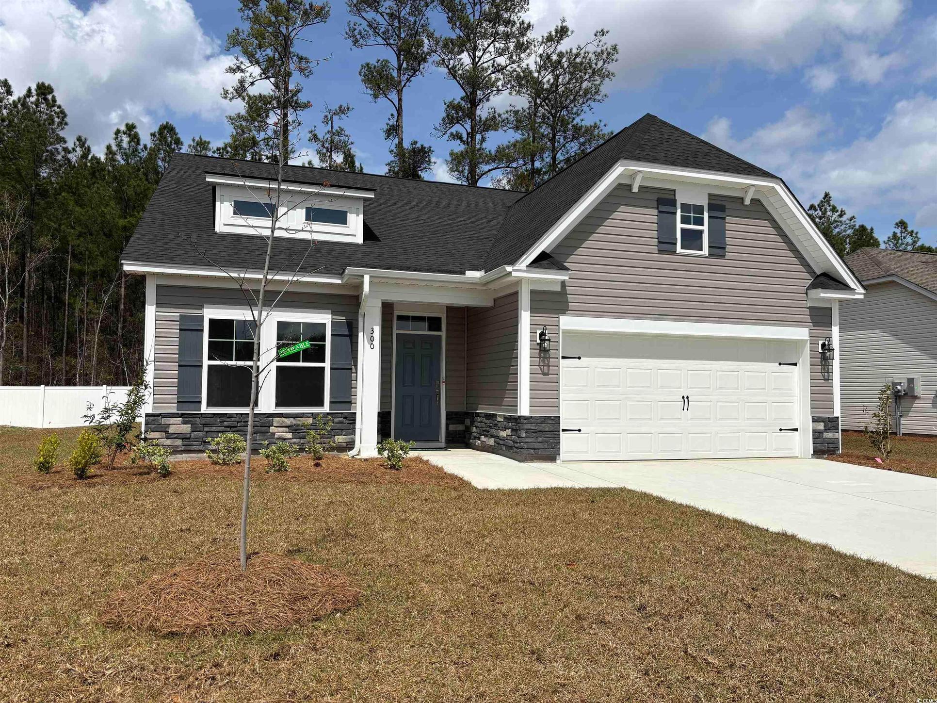 Exterior:Craftsman inspired home featuring roof with shingles, stone siding, driveway, a front yard, and a g