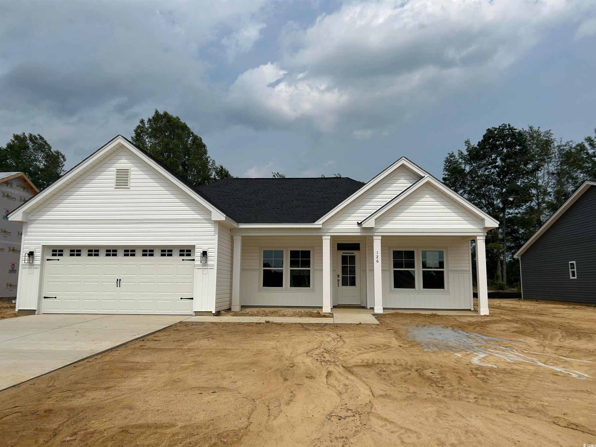 Exterior:View of front of property featuring driveway, an attached garage, covered porch, and roof with shin