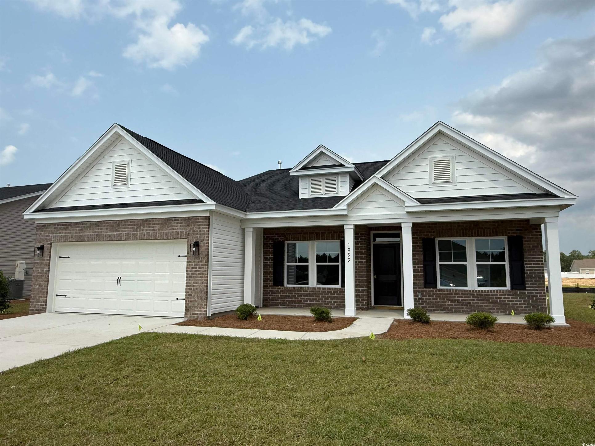 Exterior:View of front of property with brick siding, driveway, a porch, a front yard, and a garage