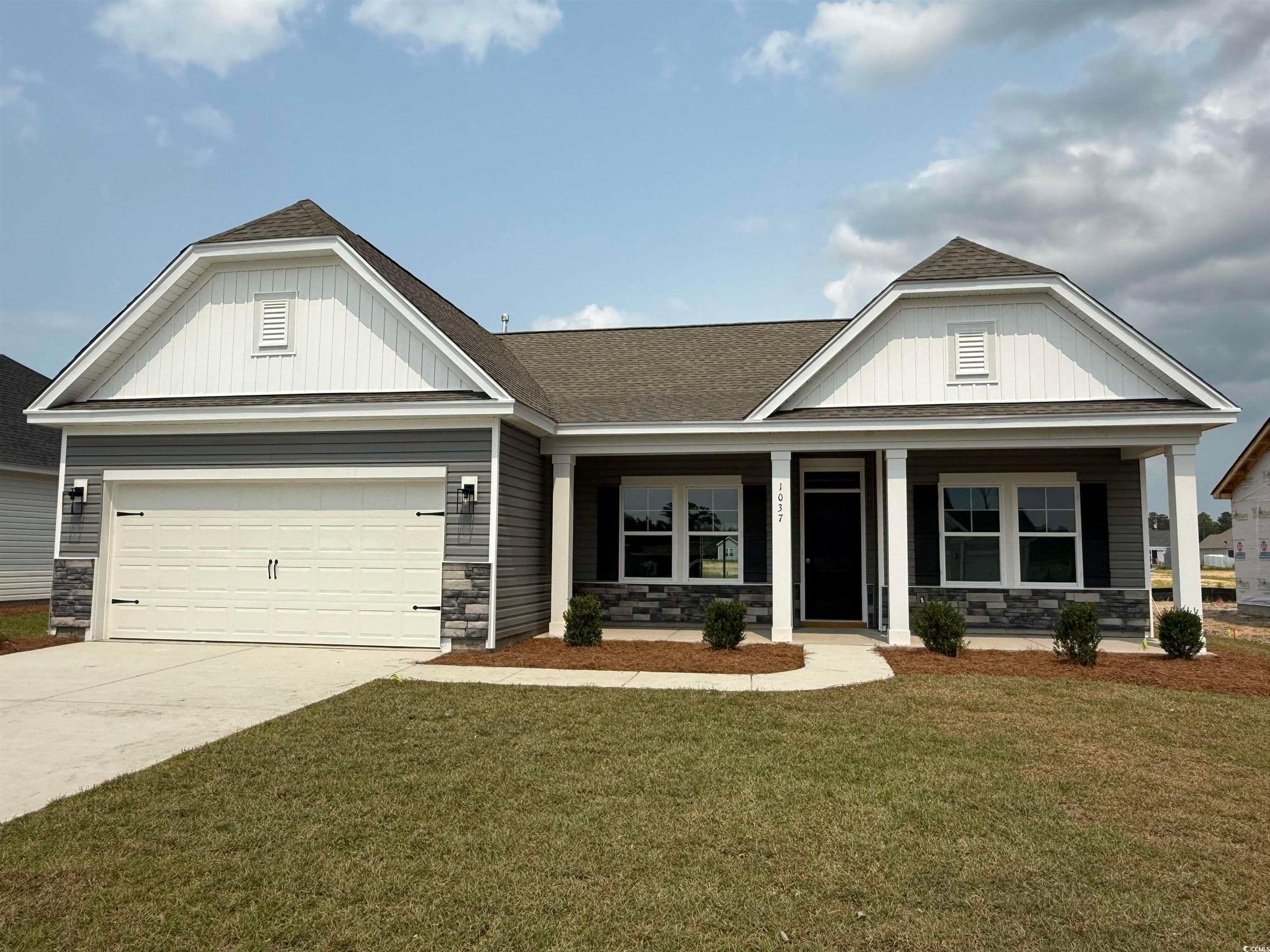 Exterior:View of front of home featuring stone siding, a front lawn, concrete driveway, covered porch, and a
