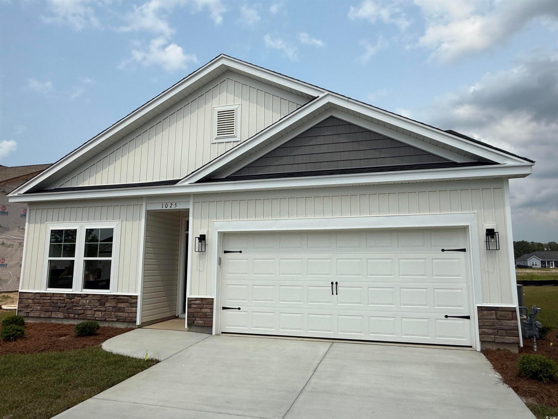 Exterior:View of front of house featuring stone siding, driveway, and a garage