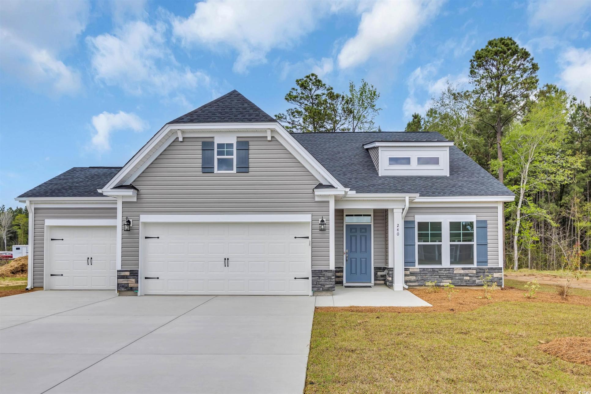 Exterior:Craftsman-style home featuring a front yard, an attached garage, stone siding, concrete driveway, a