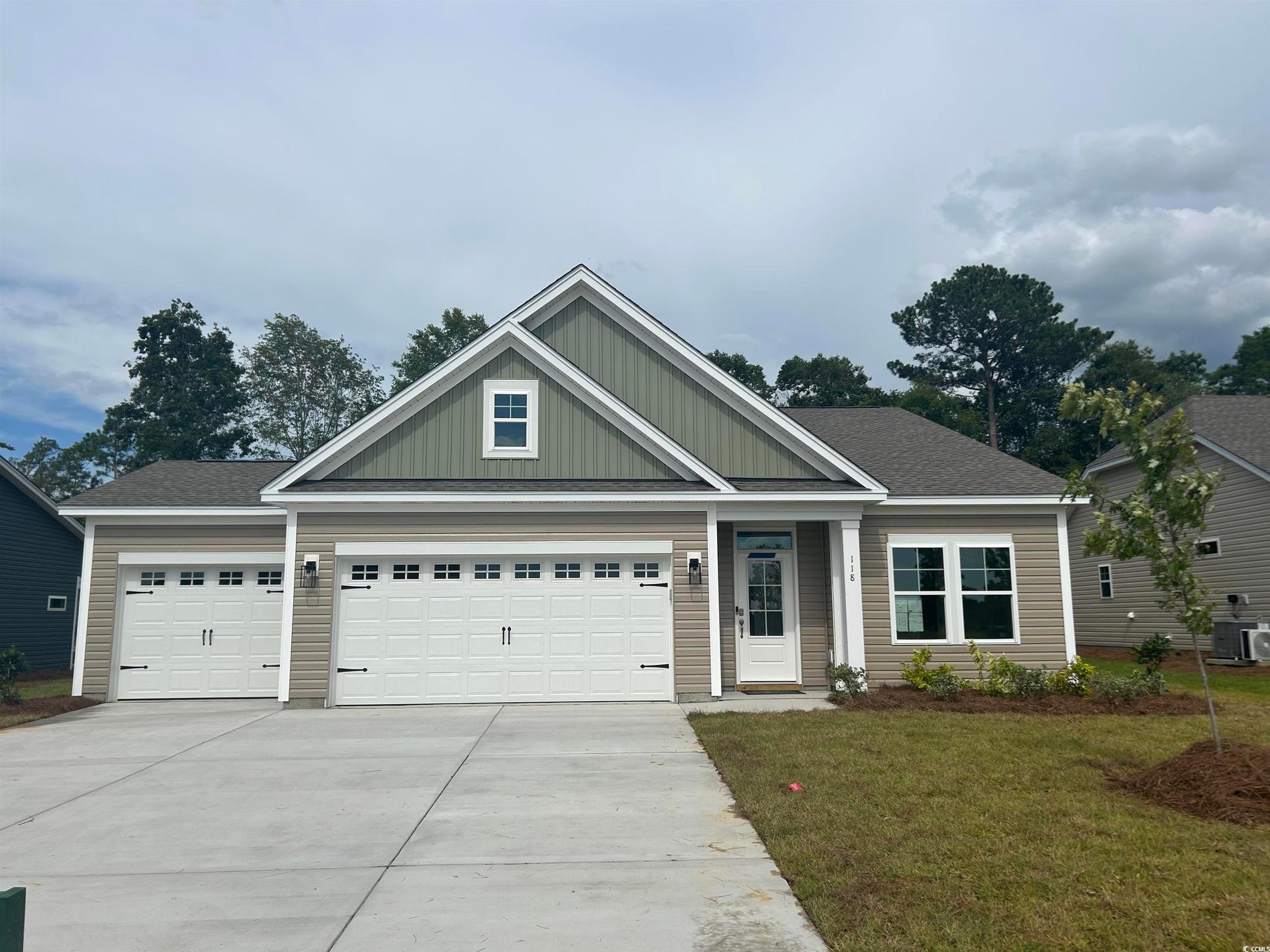 Exterior:Craftsman inspired home featuring concrete driveway, board and batten siding, a garage, a front yar