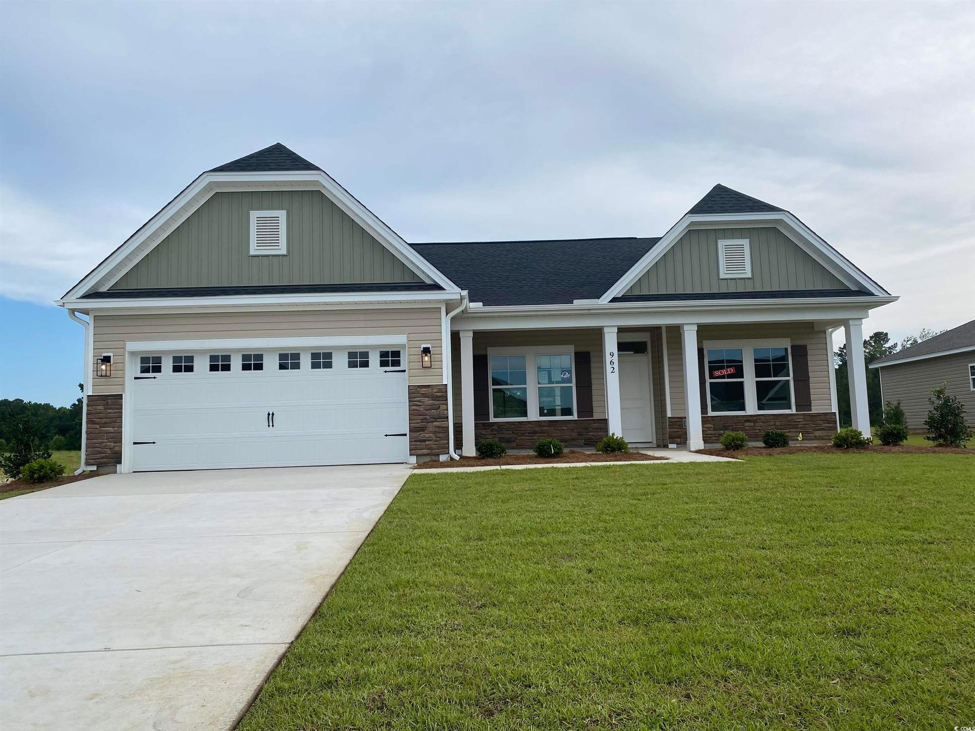 Exterior:Craftsman inspired home with a front lawn, board and batten siding, stone siding, concrete driveway
