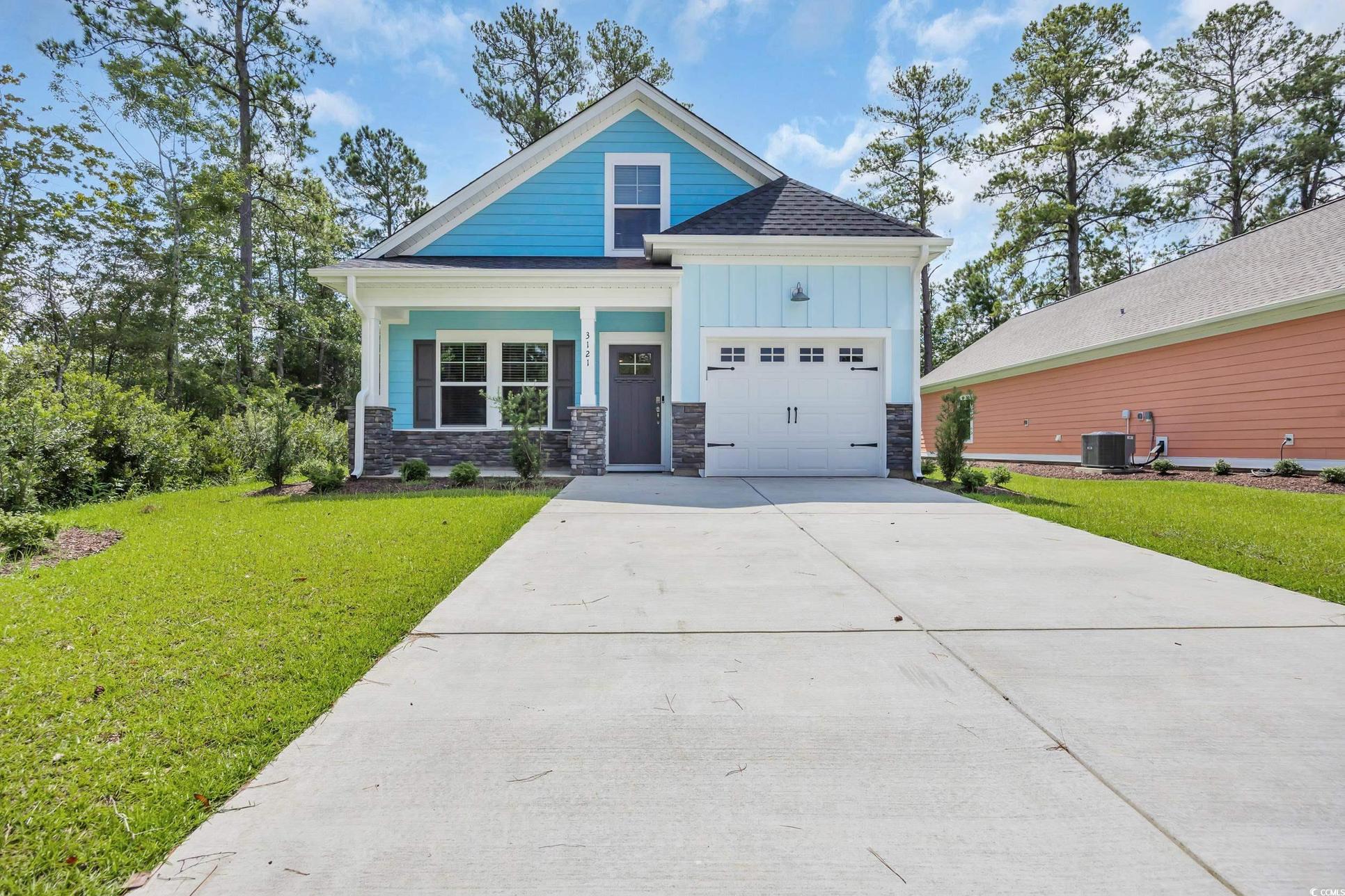 Exterior:Craftsman house featuring driveway, a front yard, board and batten siding, an attached garage, and