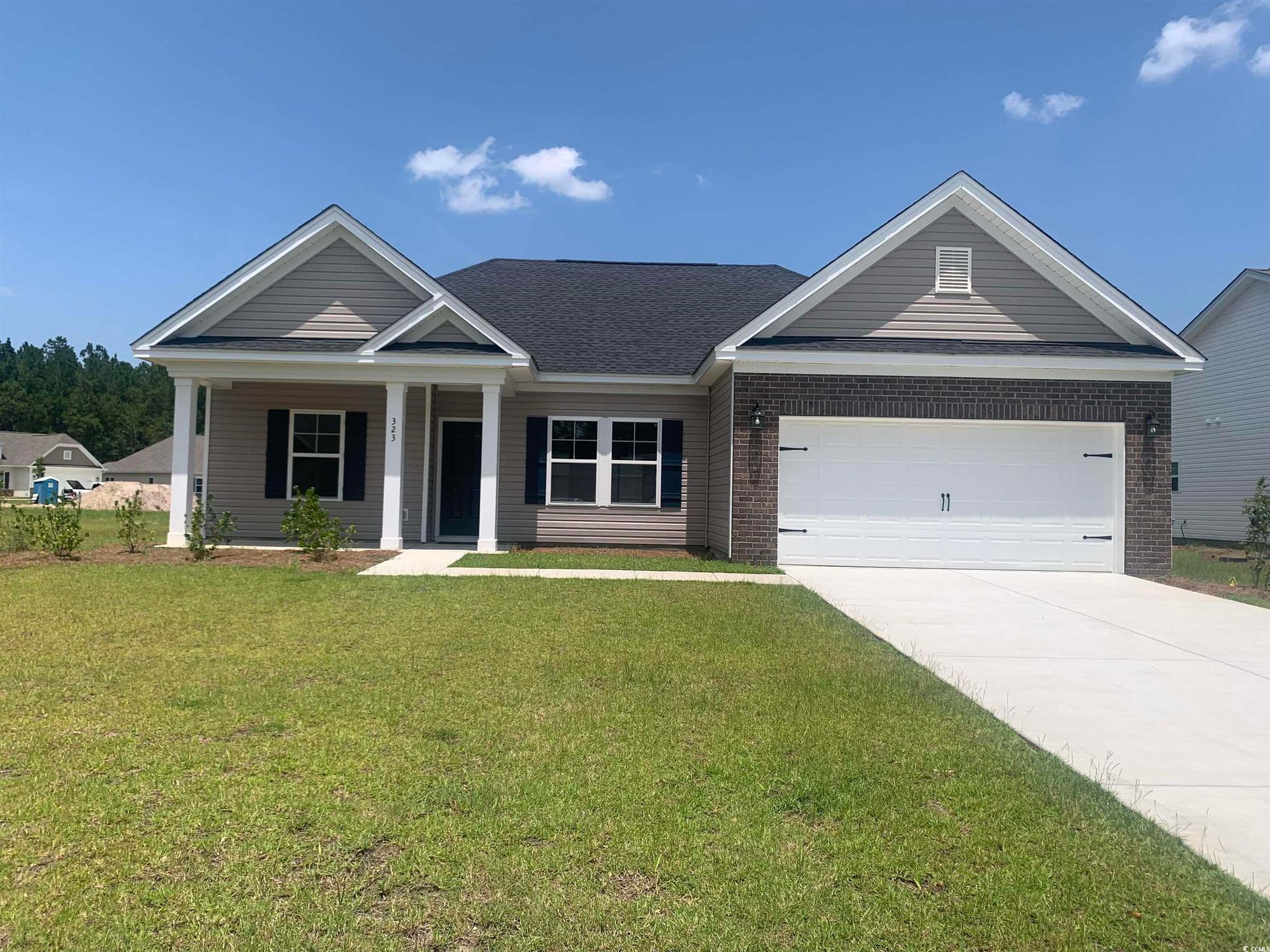 Exterior:View of front of property featuring brick siding, driveway, a garage, and a front lawn