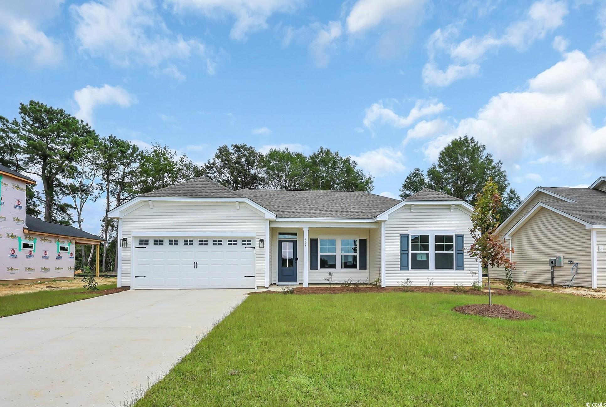 Exterior:Single story home with concrete driveway, a front yard, an attached garage, and roof with shingles