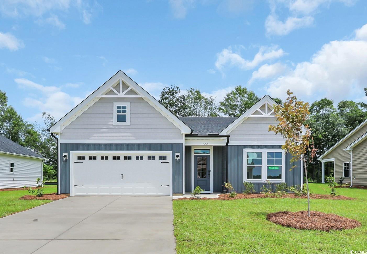 Exterior:View of front of property with board and batten siding, a garage, and a front lawn