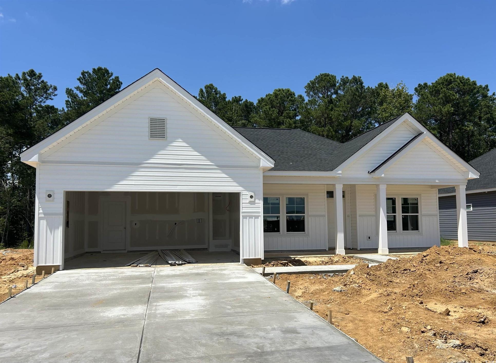 Exterior:View of front of house featuring driveway, a garage, a porch, and a shingled roof